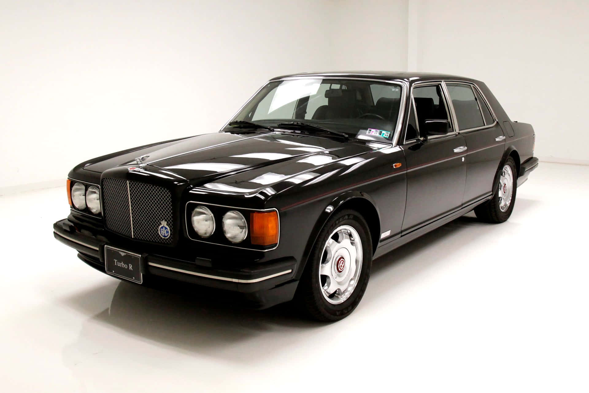 Bentley Turbo R 桌布 壁紙 — 一輛時尚的黑色賓利Turbo R豪華轎車在明亮的攝影棚燈光下，在純白背景上閃閃發光。