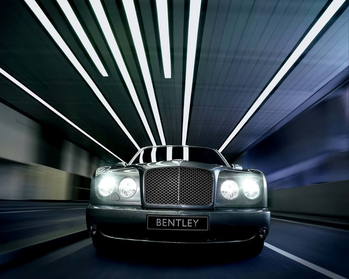 Bentley Azure 桌布 壁紙 — 一輛時尚的黑色賓利在隧道中疾馳，白色天花燈光飛掠而過。
