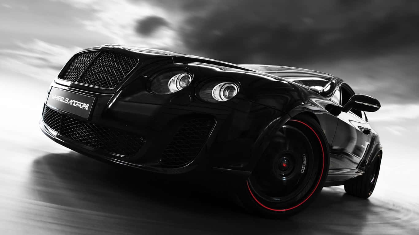 1366x768 Bentley 桌布 壁紙 — 一輛時尚的黑色賓利跑車配紅色輪圈，在戲劇性的多雲天空下疾馳。