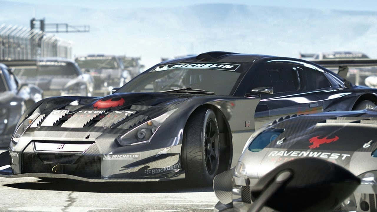 720p Grid Autosport 桌布 壁紙 — 一輛時尚的黑色賽車，帶有碳纖維細節和米其林品牌，在陽光明媚的賽道上佔據主導地位，背景中有其他競爭對手。