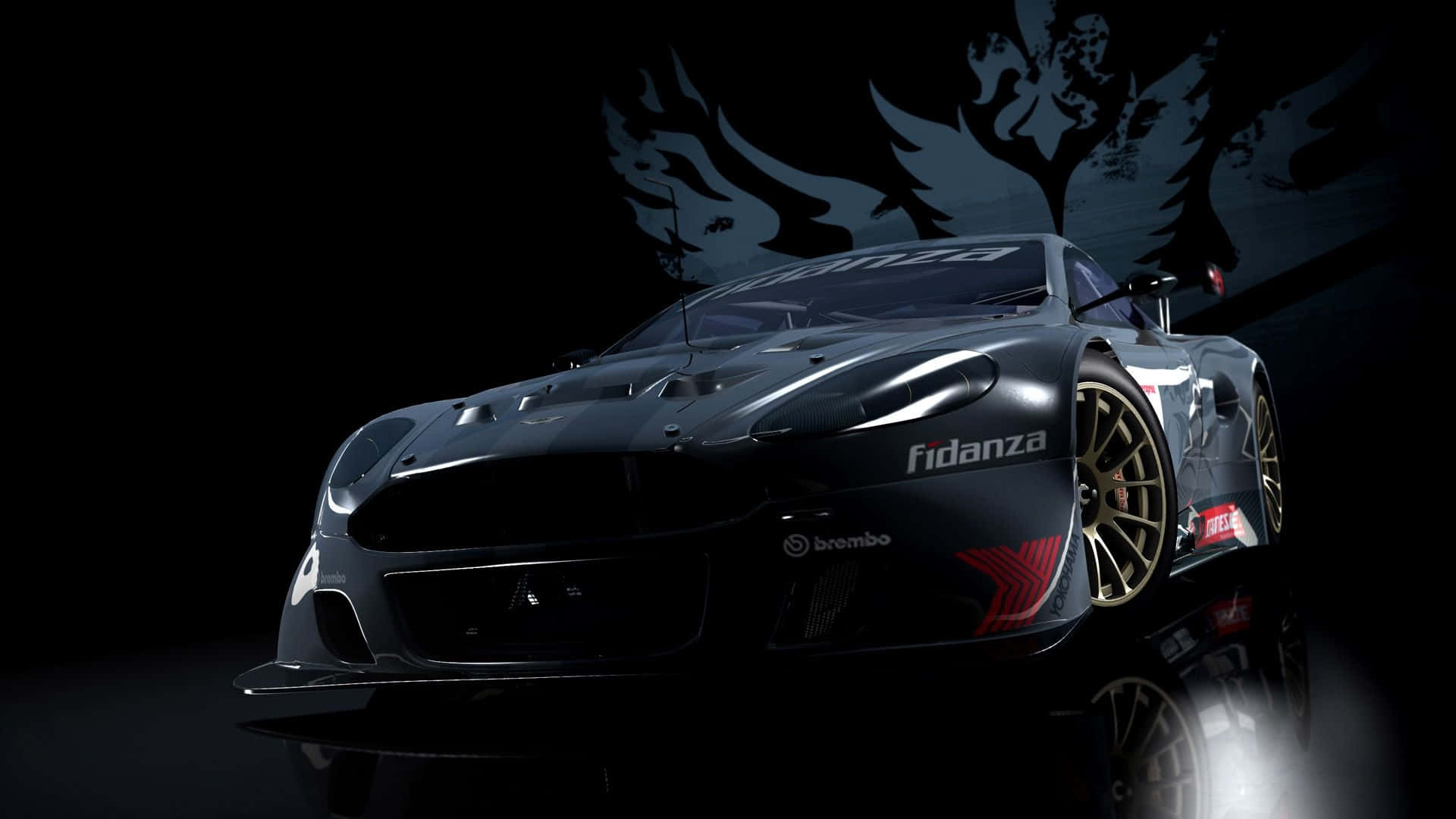 race car 桌布 壁紙 — 一輛時尚的黑色賽車，配備金色輪圈和紅色點綴，在戲劇性的攝影棚燈光下，於帶有翼形標誌的深色背景中閃耀。