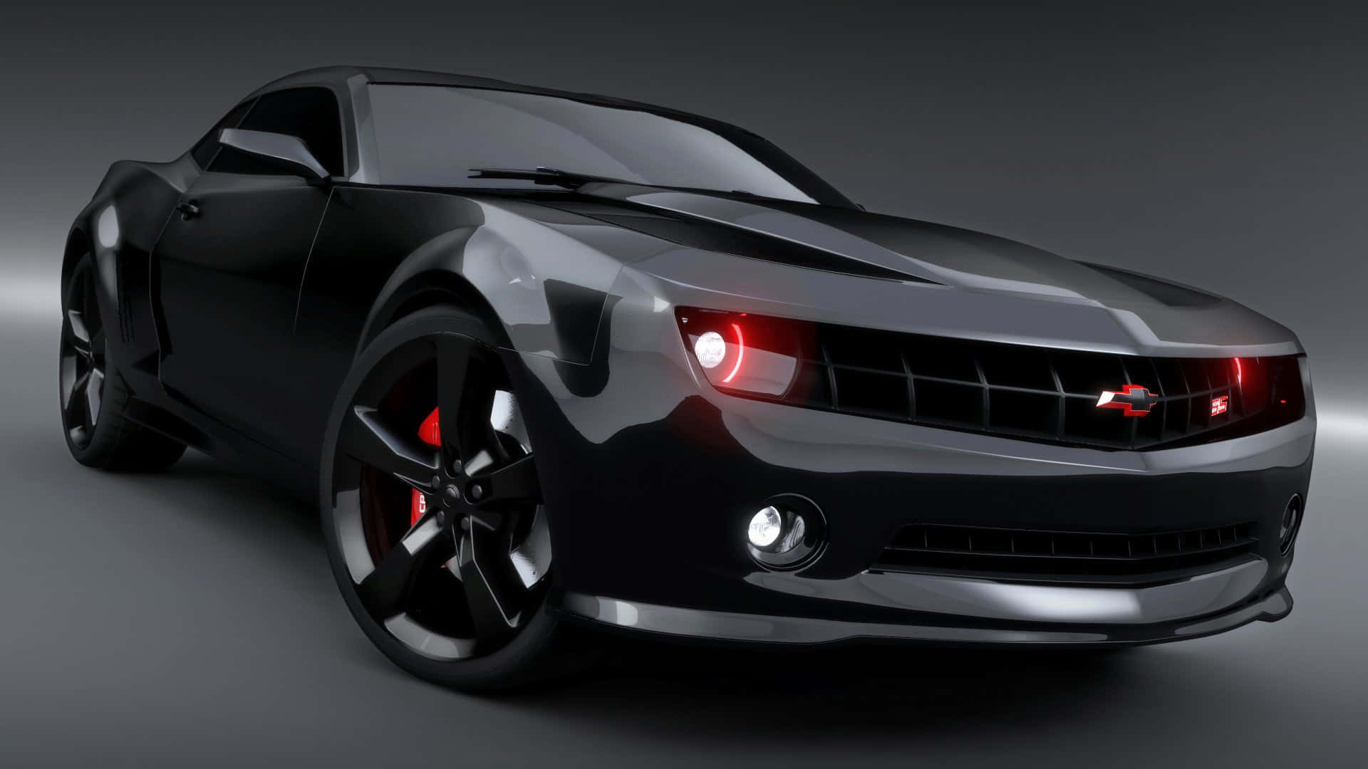 Cool Camaro 桌布 壁紙 — 一輛時尚的黑色跑車，帶有發光的紅色頭燈和制動卡鉗，置於深色攝影棚背景前。