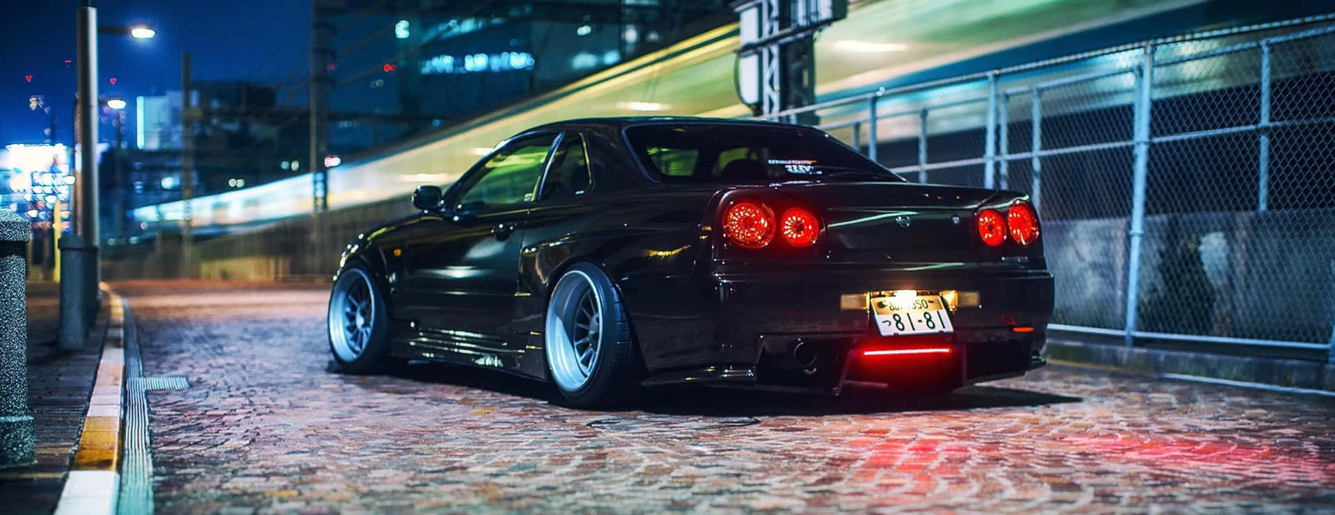 黑色跑車帶紅色尾燈停在夜晚鵝卵石街道上。 — Toyota Supra Mk4 壁紙