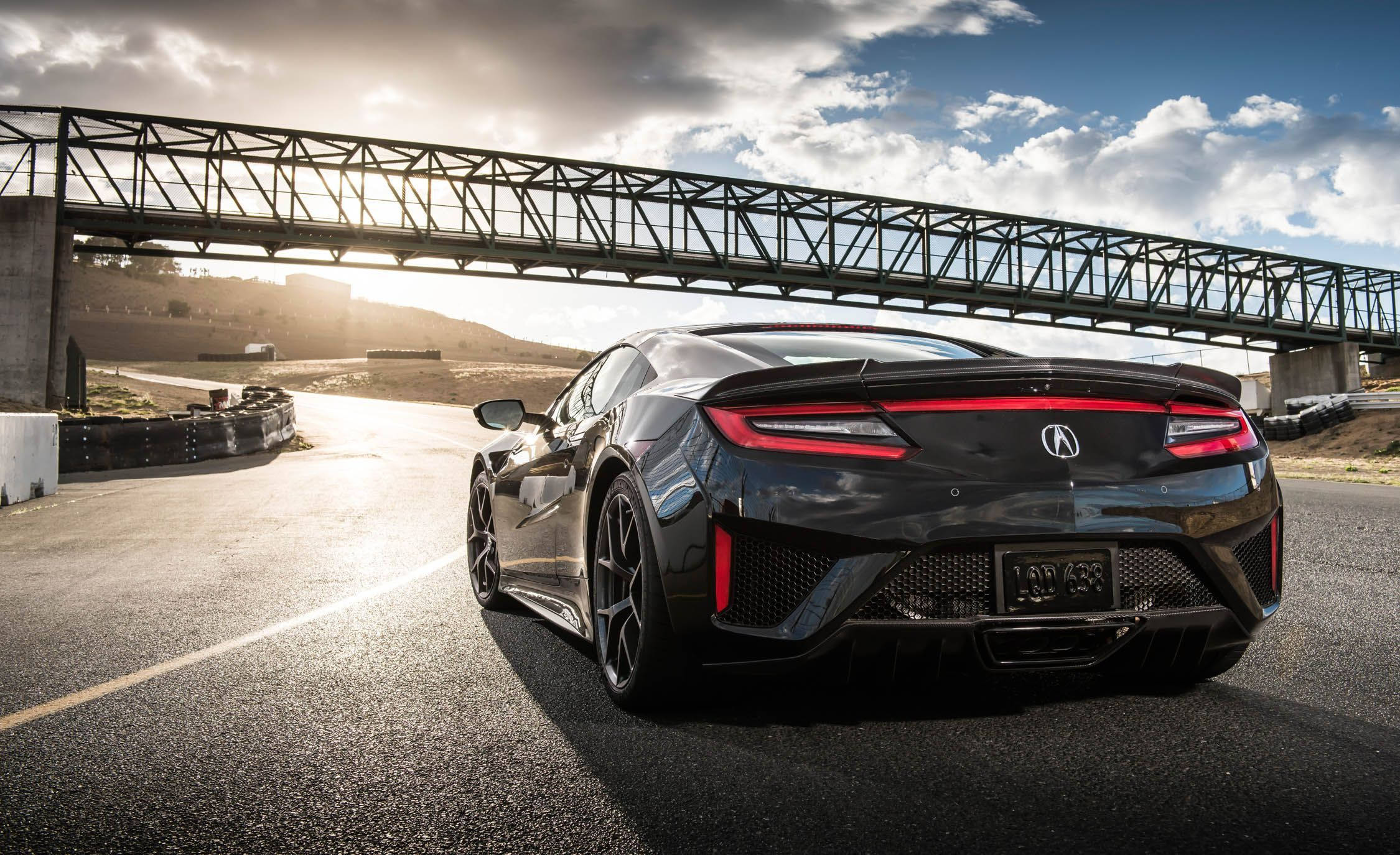 Acura 桌布 壁紙 — 一輛時尚的黑色跑車，帶有發光的紅色尾燈，在黃金時段駛過鋼橋下。