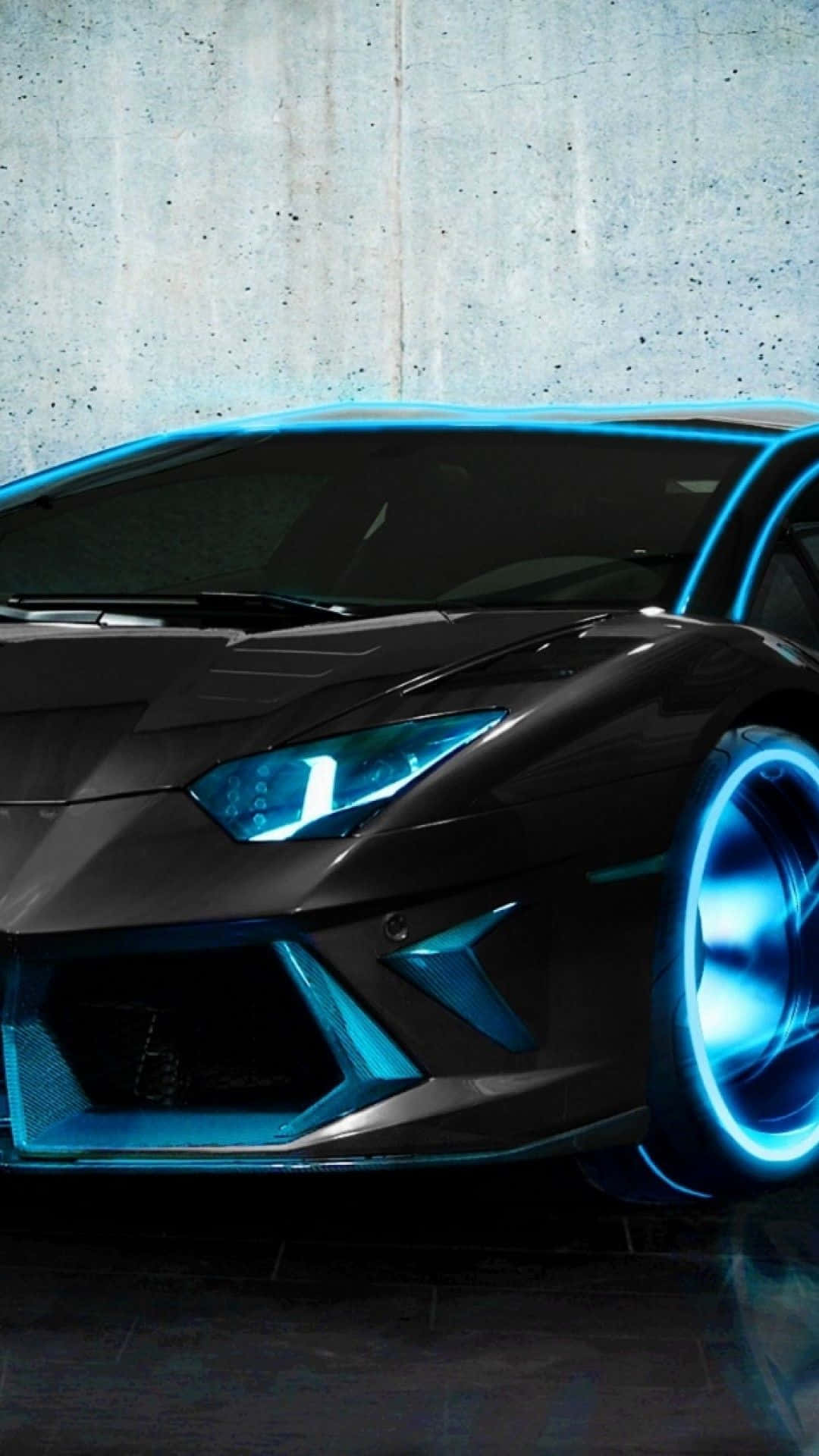 Pixel 3xl Lamborghini 桌布 壁紙 — 一輛時尚的黑色跑車，帶有發光的藍色飾邊和霓虹燈車輪，停靠在紋理混凝土牆旁。