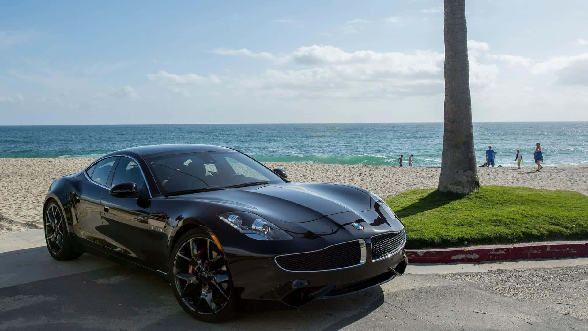 Fisker 桌布 壁紙 — 一輛時尚的黑色跑車停泊在陽光明媚的海濱道路上，背景有棕櫚樹和海浪。