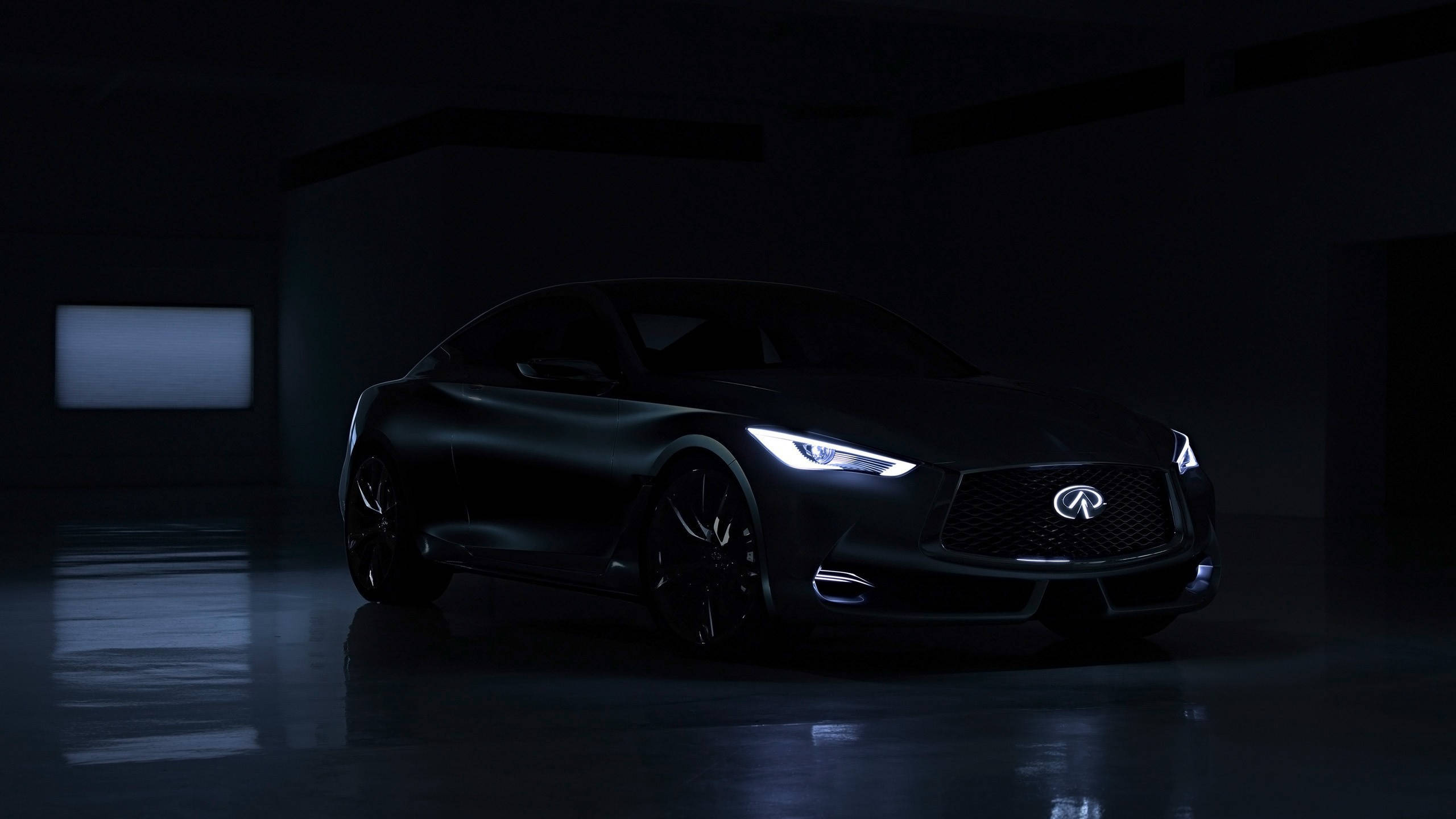 Infiniti 桌布 壁紙 — 一輛時尚的黑色跑車在光線昏暗、地板反光的地下車庫中閃爍著銳利的車頭燈。