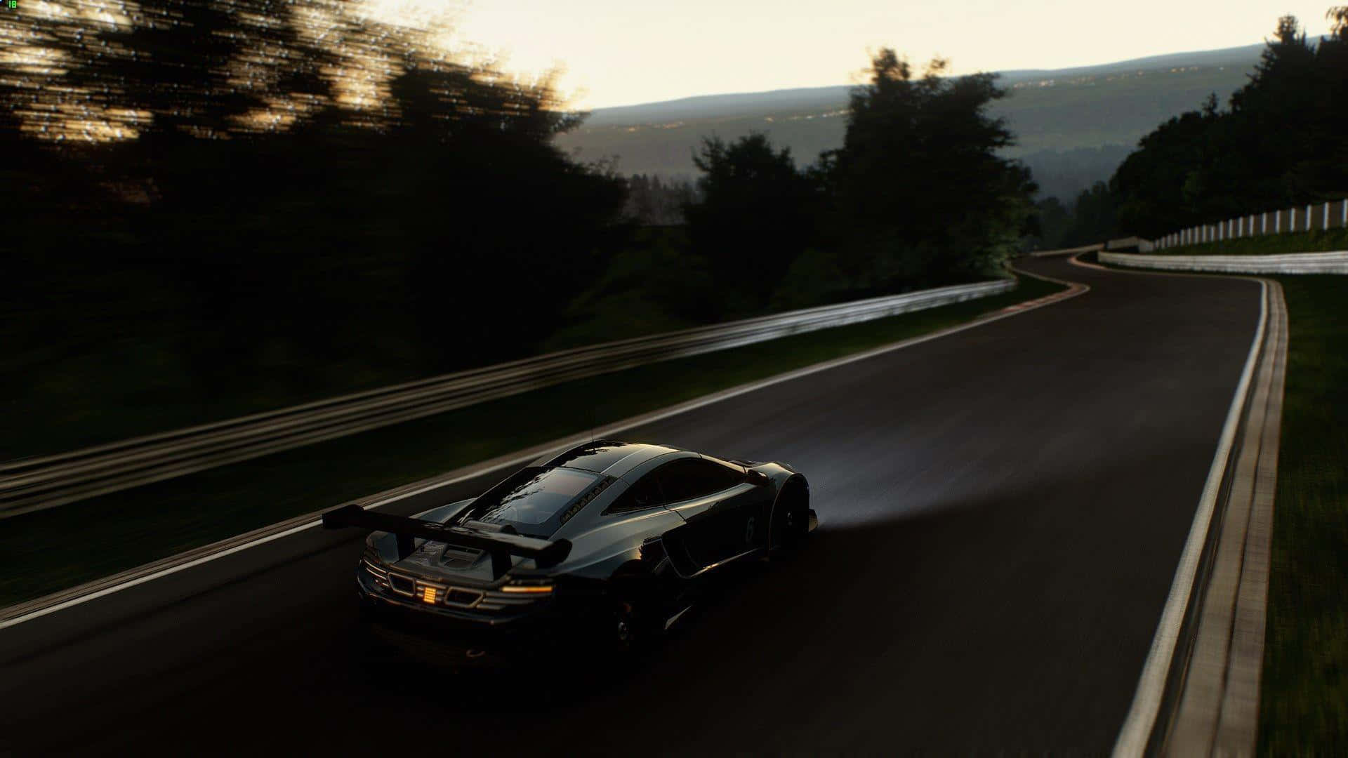 Best Project Cars 2 桌布 壁紙 — 一輛時尚的黑色跑車在日落時分沿著蜿蜒的山路疾馳，背景是模糊的樹木和遠處的山丘。