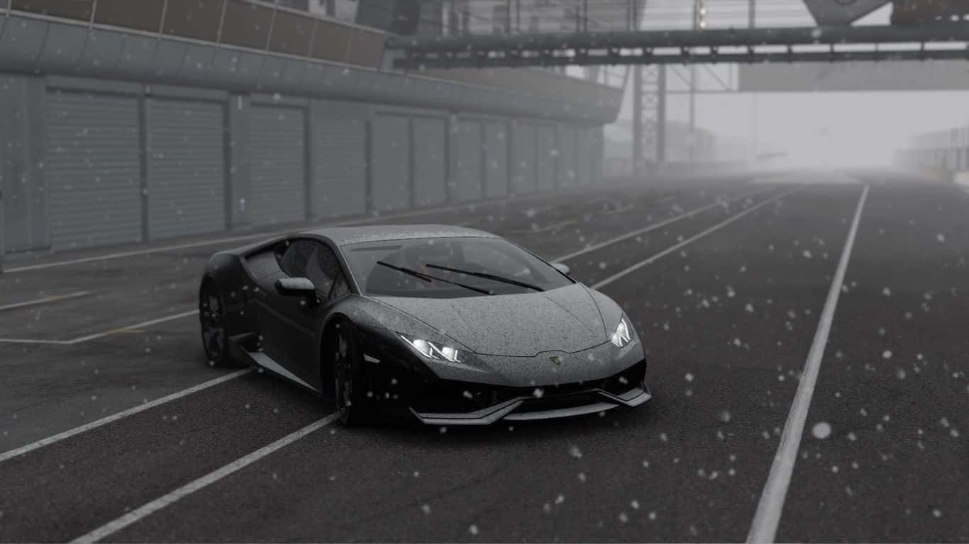 1366x768 Project Cars 2 桌布 壁紙 — 一輛時尚的黑色跑車在灰濛濛的天空下，雪花飄落中，滑過白雪覆蓋的賽道。