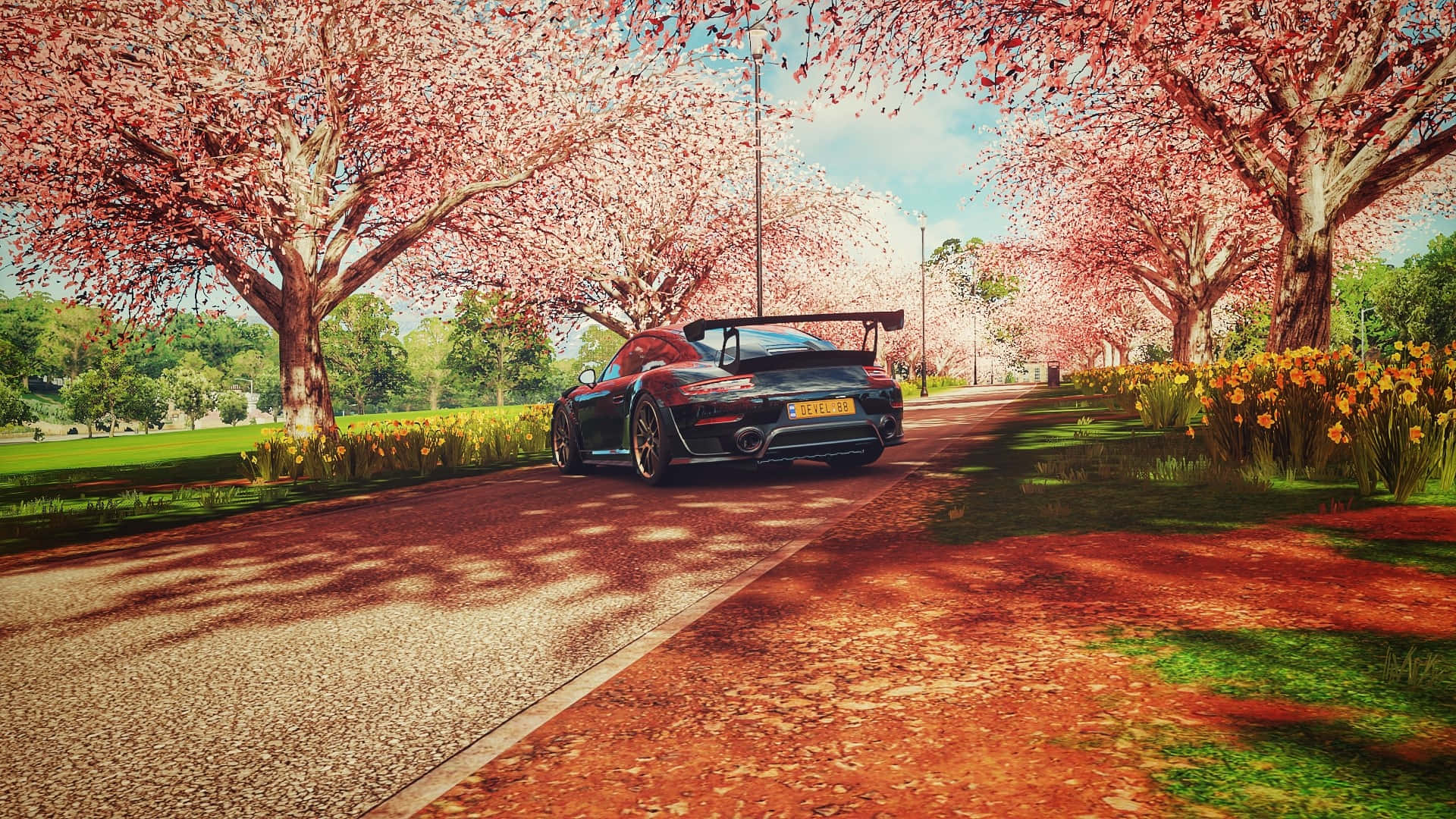 1920x1080 Forza Horizon 4 桌布 壁紙 — 一輛時尚的黑色跑車在陽光明媚的道路上行駛，道路兩旁盛開的櫻花樹投下斑駁的陰影。