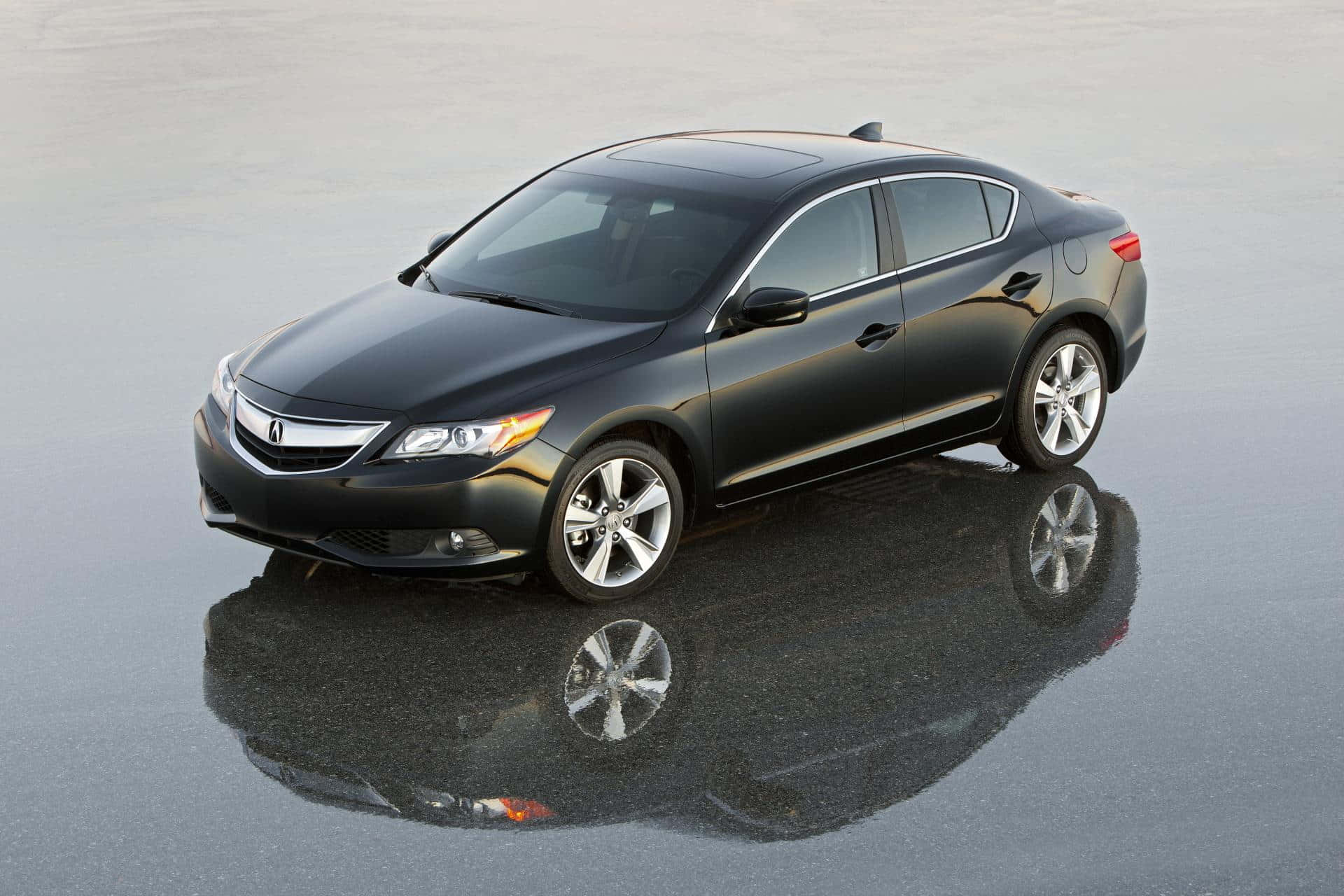 Acura Ilx 桌布 壁紙 — 一輛時尚的黑色轎車在柔和的日光下完美地倒映在潮濕的瀝青路面上。