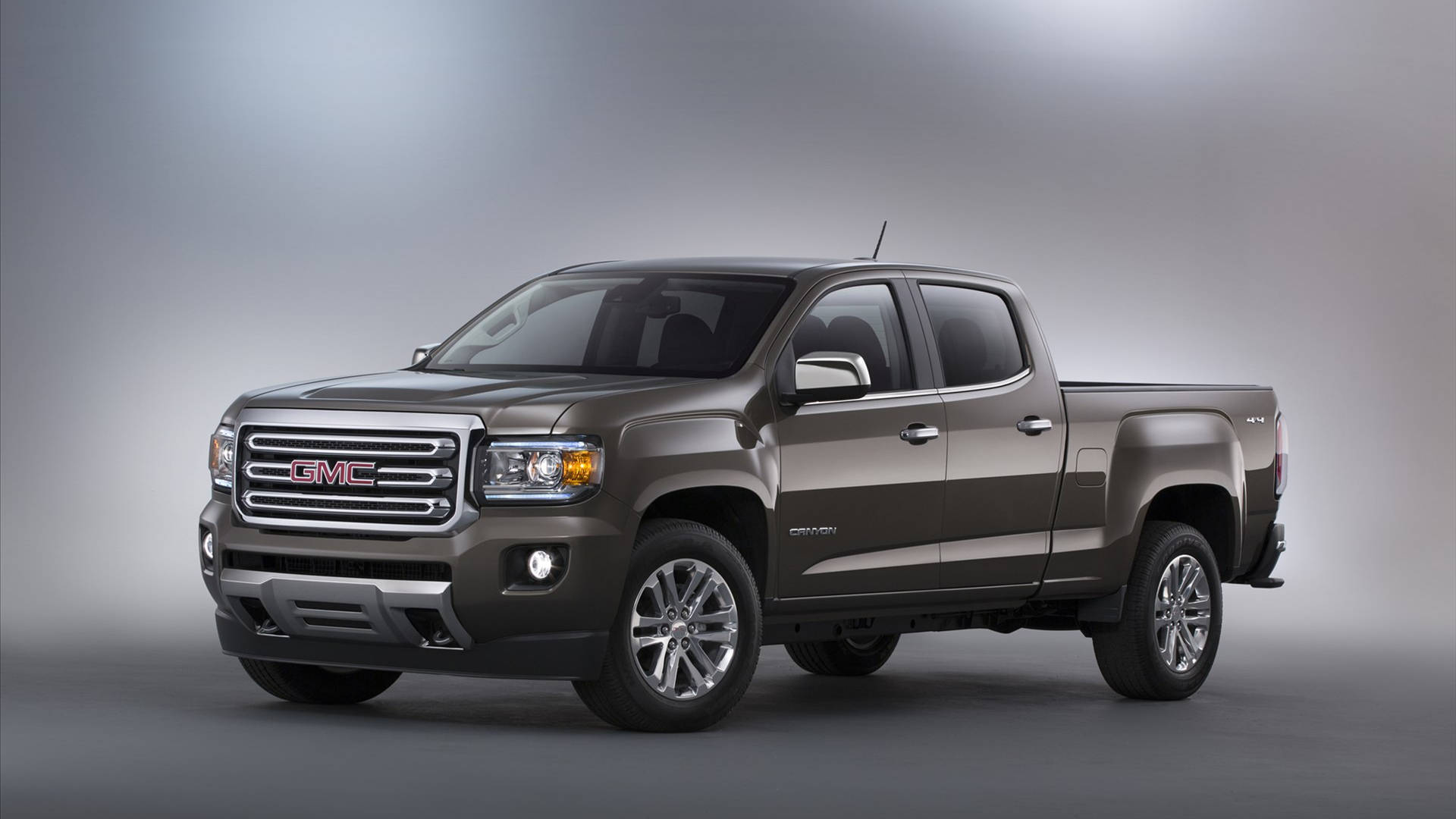 Gmc 桌布 壁紙 — 一輛時尚金屬棕色的GMC Canyon皮卡車在工作室中展示，配有柔和漸變燈光。
