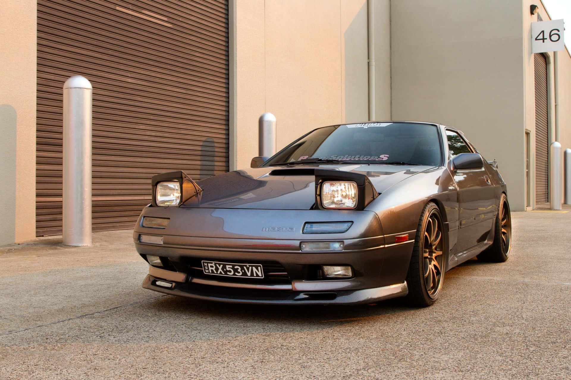 Rx7 Fc 桌布 壁紙 — 一輛時尚金屬灰色的日產300ZX跑車停在設有棕色捲簾門的倉庫前。