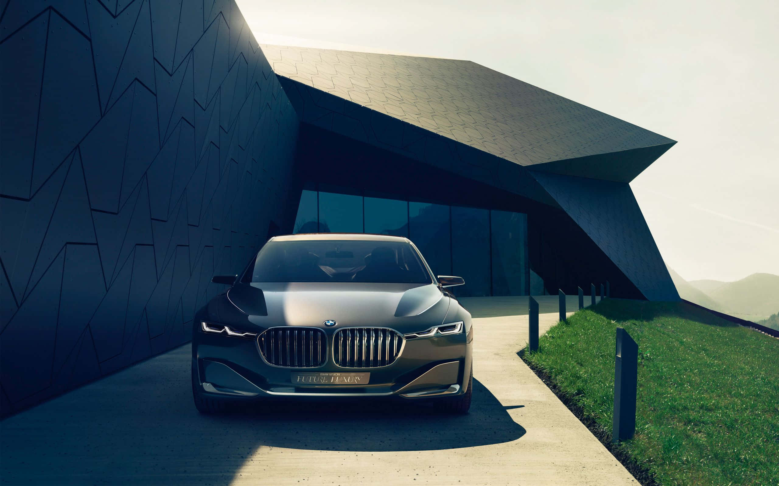 高清 桌布 壁紙 — 一輛時尚金屬質感的BMW概念車停放在一座現代稜角建築下，建築帶有幾何牆壁和草地斜坡。