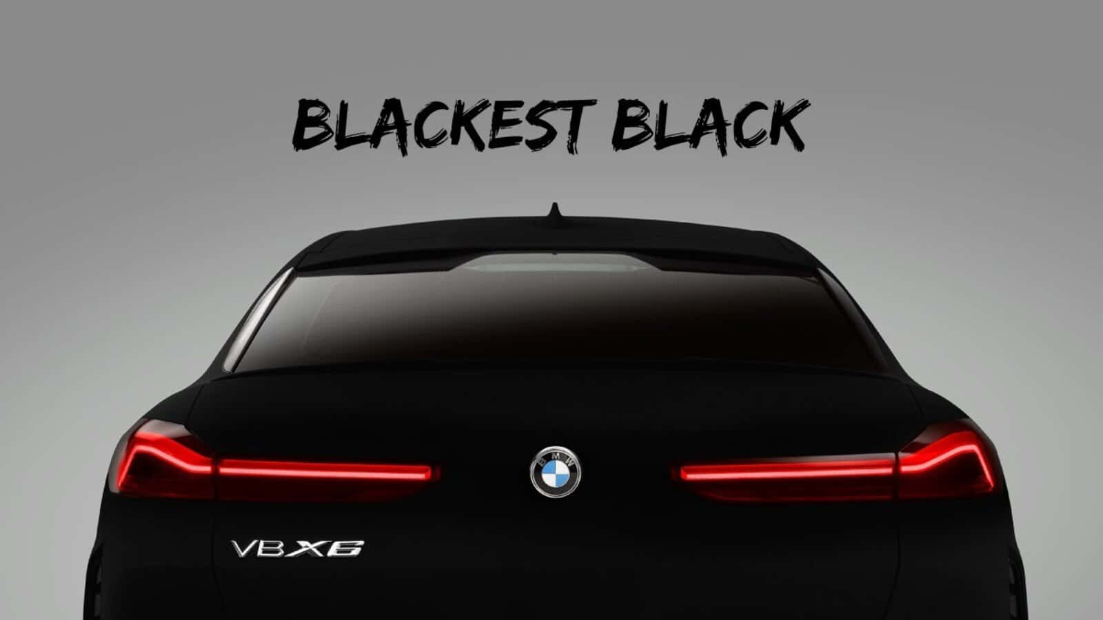 Vantablack 桌布 壁紙 — 一輛時尚黑色BMW V8X6的後視圖，帶有發光的紅色尾燈，背景為簡約灰色。