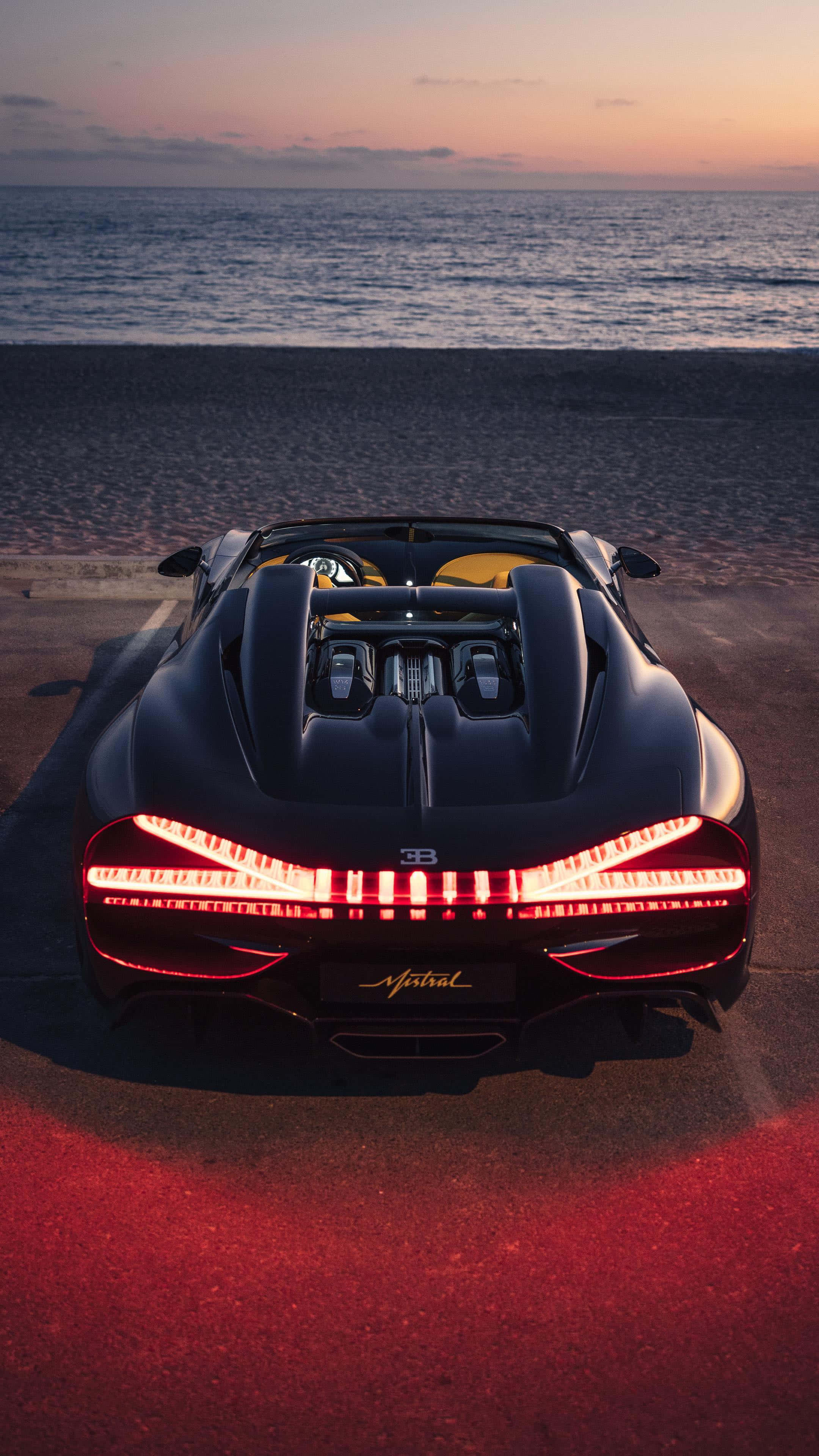 Bugatti Phone 桌布 壁紙 — 一輛時尚黑色Bugatti Chiron Super Sport 300+敞篷車，帶有發光的紅色尾燈，停在日落時分的沙灘上。