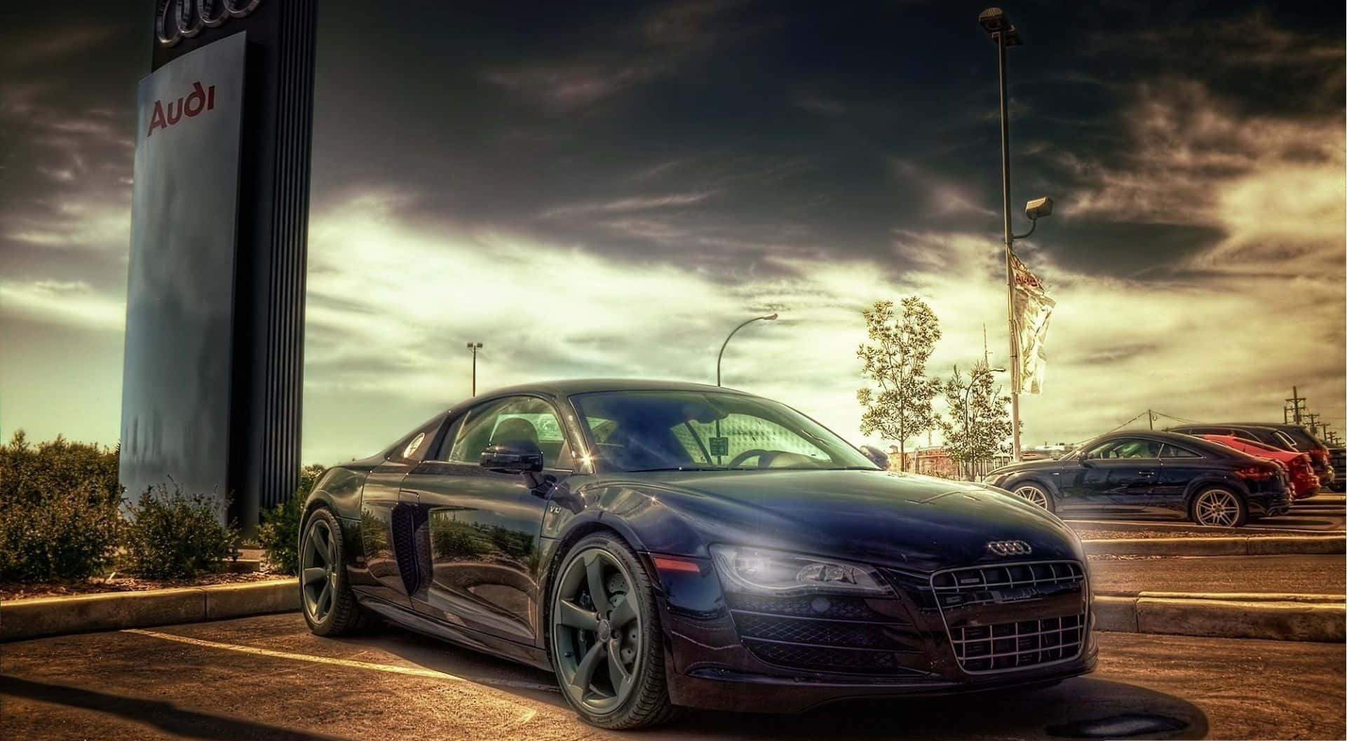 4K Hdr 桌布 壁紙 — 一輛時尚黑色奧迪R8跑車在經銷商停車場中，在戲劇性的金色日落光線下閃閃發光。
