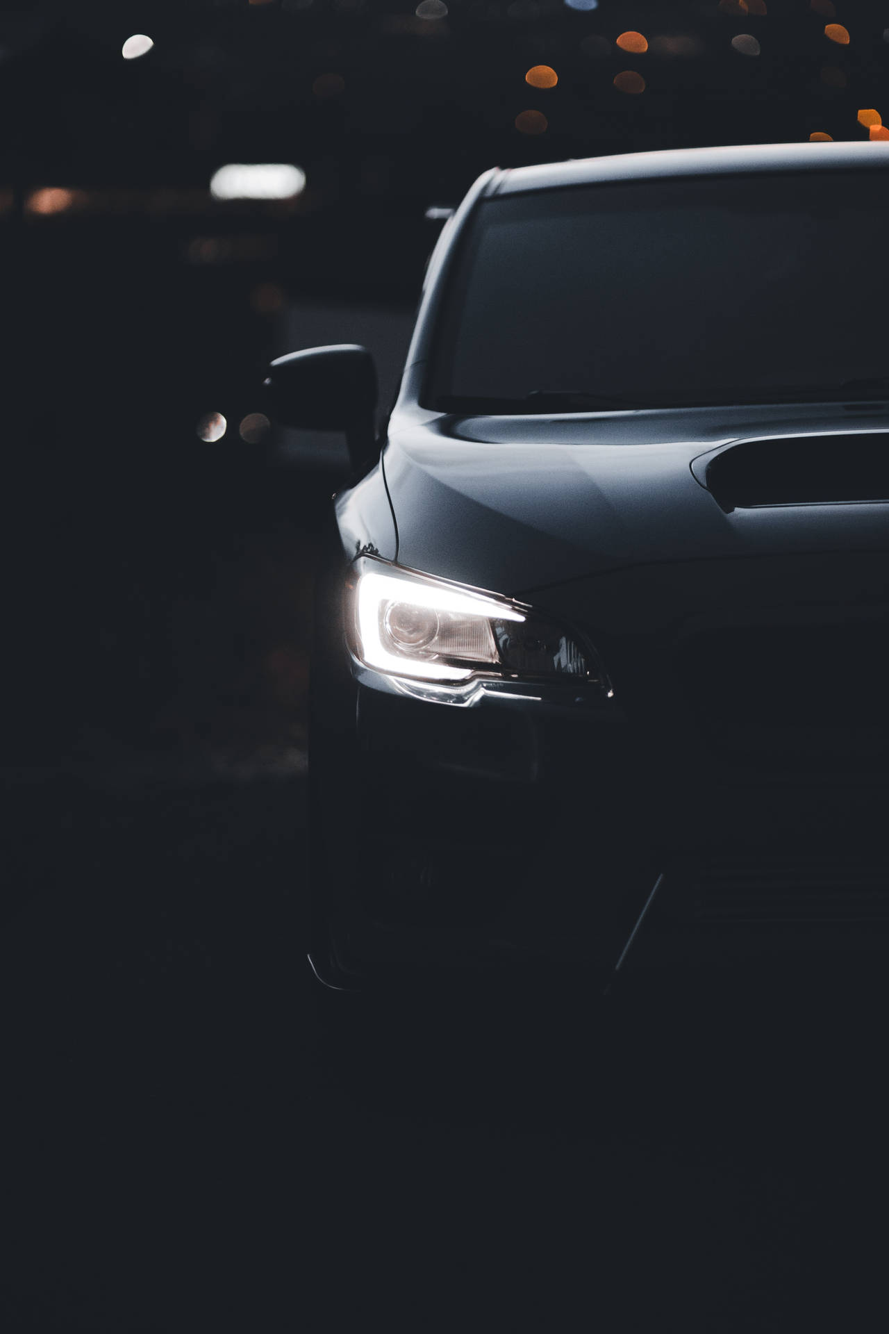 黑色汽車車頭燈在夜間城市環境中閃耀，帶有模糊燈光。 — 1920x1080 4K 壁紙