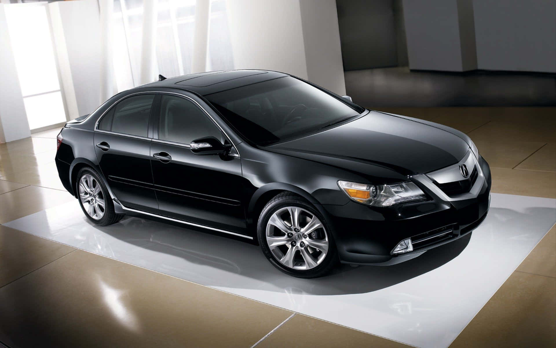 Acura Tsx 桌布 壁紙 — 一輛時尚黑色轎車在極簡現代展廳的白色平台上，於工作室燈光下閃閃發光。