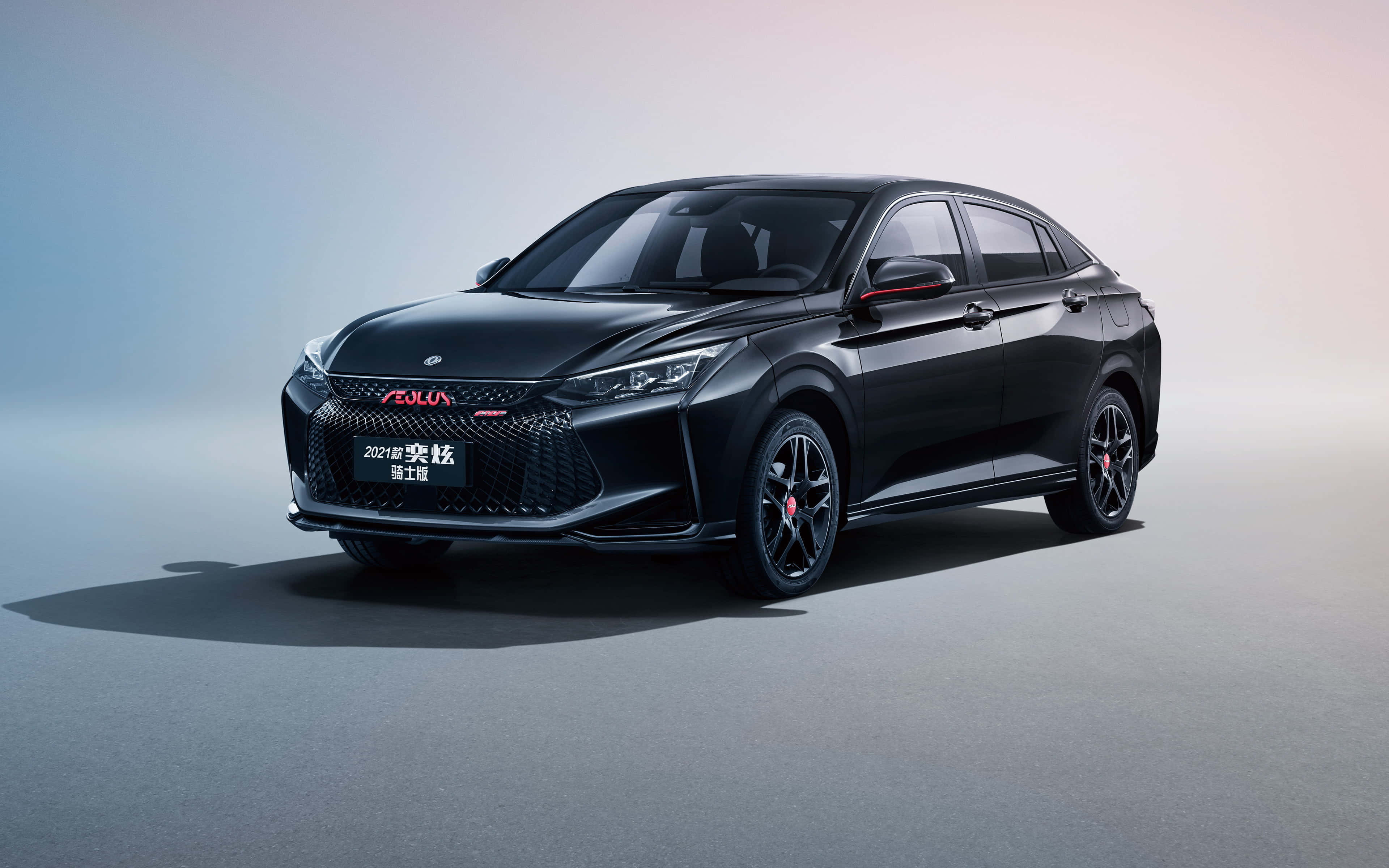 Dongfeng 桌布 壁紙 — 一輛時尚黑色轎車配以紅色點綴和運動型輪圈，在簡約工作室環境中搭配柔和漸變燈光展示。