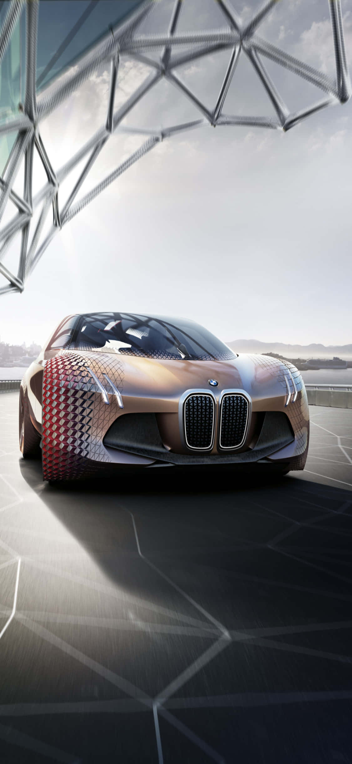 iPhone X Bmw 桌布 壁紙 — 一輛未來感十足的BMW概念車，帶有幾何紅色和古銅色圖案，停放在金屬網格結構下的時尚平台上。