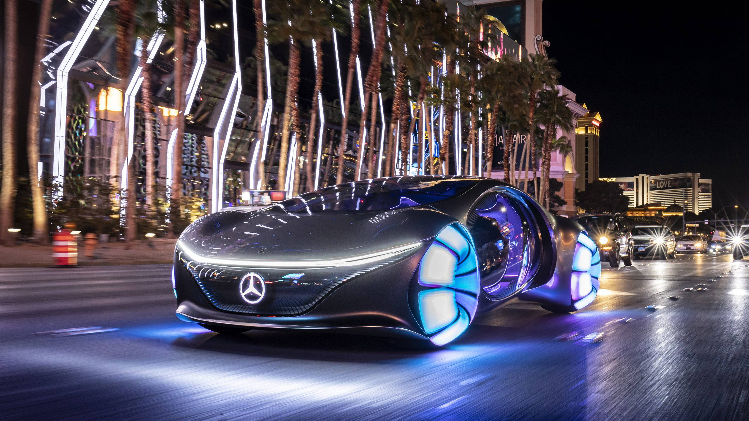 Mercedes 桌布 壁紙 — 一輛未來感十足的梅賽德斯-奔馳概念車在霓虹閃爍的拉斯維加斯夜晚街道上奔馳，發出藍色光芒。