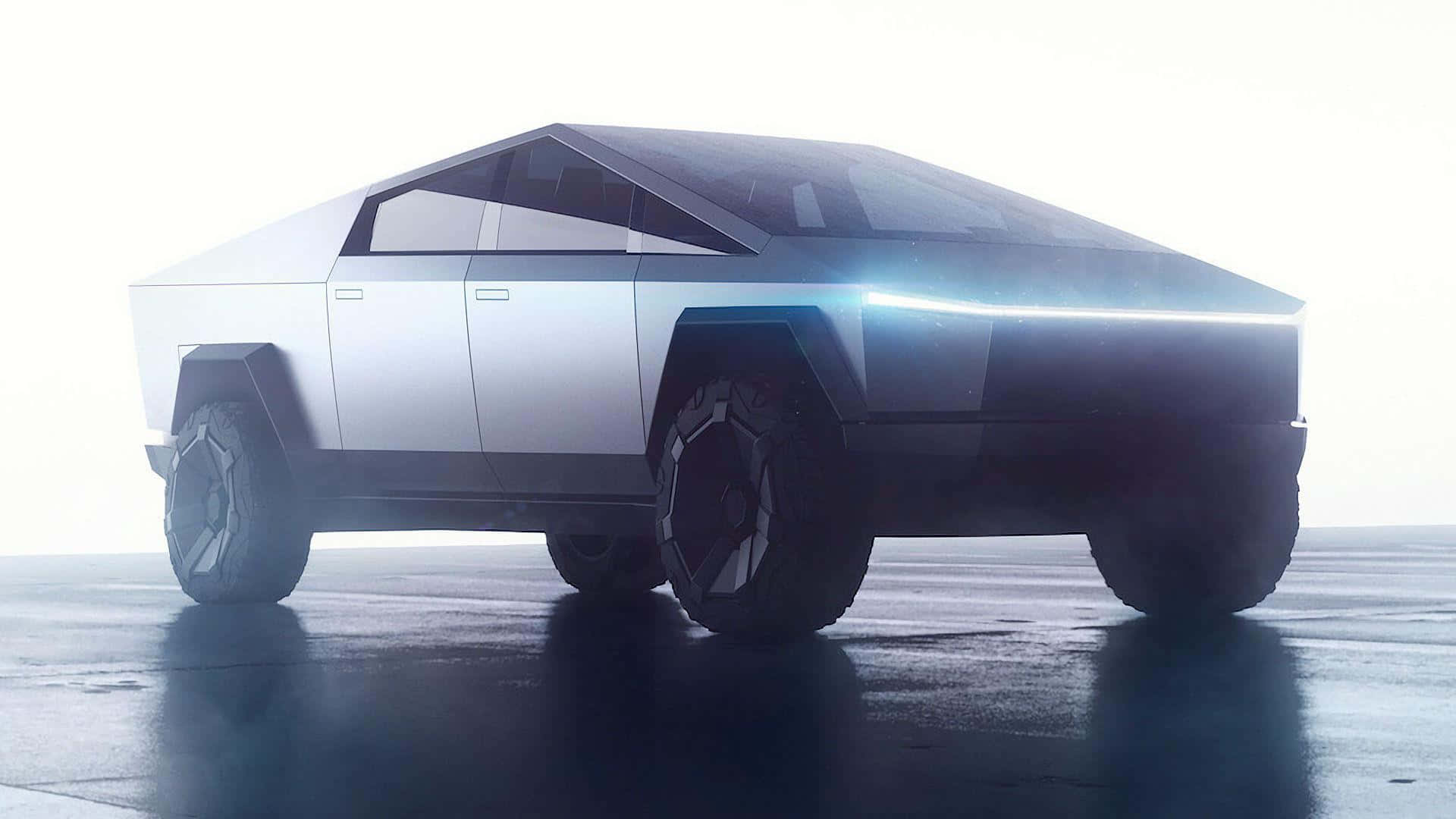Tesla Cybertruck 桌布 壁紙 — 一輛未來感十足的銀色 Cybertruck，具有銳利的棱角線條和發光的藍色頭燈，在明亮的攝影棚燈光下站在反射的濕表面上。