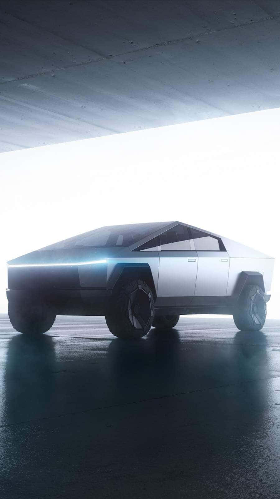 Tesla Cybertruck 桌布 壁紙 — 一輛未來感十足的銀色Cybertruck在混凝土天橋下的濕滑路面上閃閃發光。