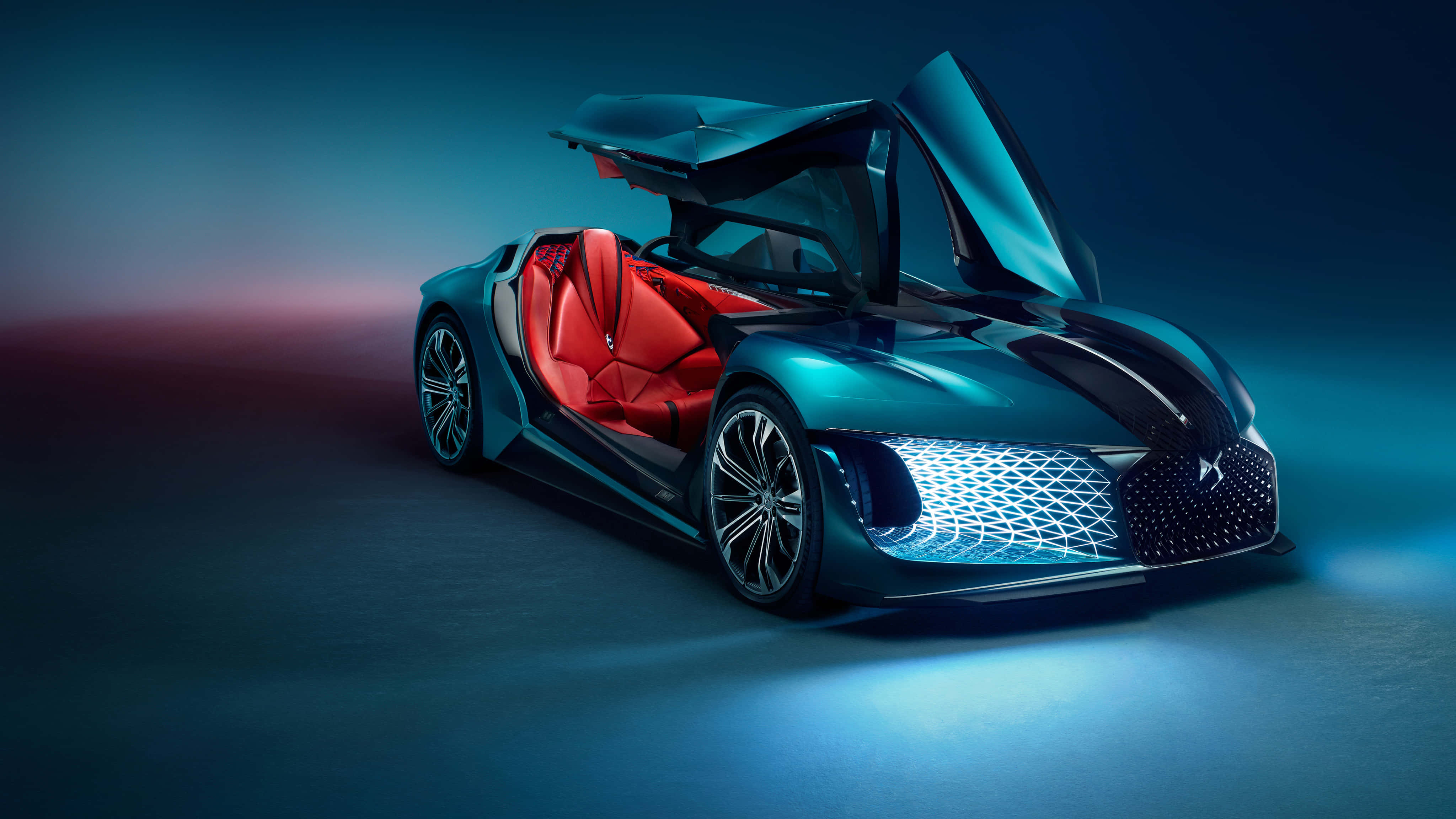 Ds Automobiles 桌布 壁紙 — 一輛未來感的藍綠色跑車，帶有發光的藍色飾邊和紅色內裝，置於戲劇性的攝影棚燈光下。