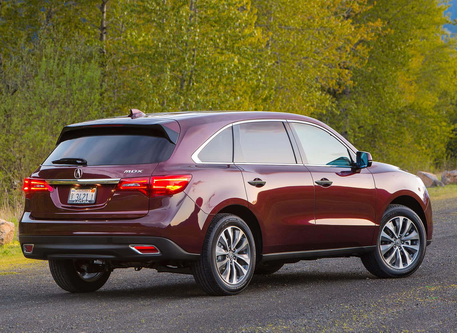 Acura Mdx 桌布 壁紙 — 一輛栗色Acura MDX SUV停泊在碎石路上，背景有綠樹。