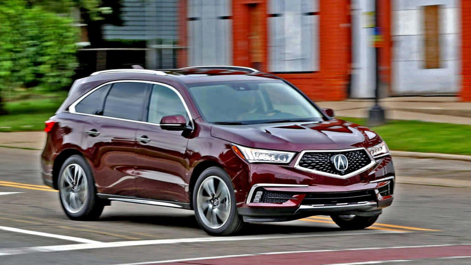Acura Mdx 桌布 壁紙 — 一輛栗色Acura SUV在模糊的建築物和綠化背景中，於城市街道上飛馳。