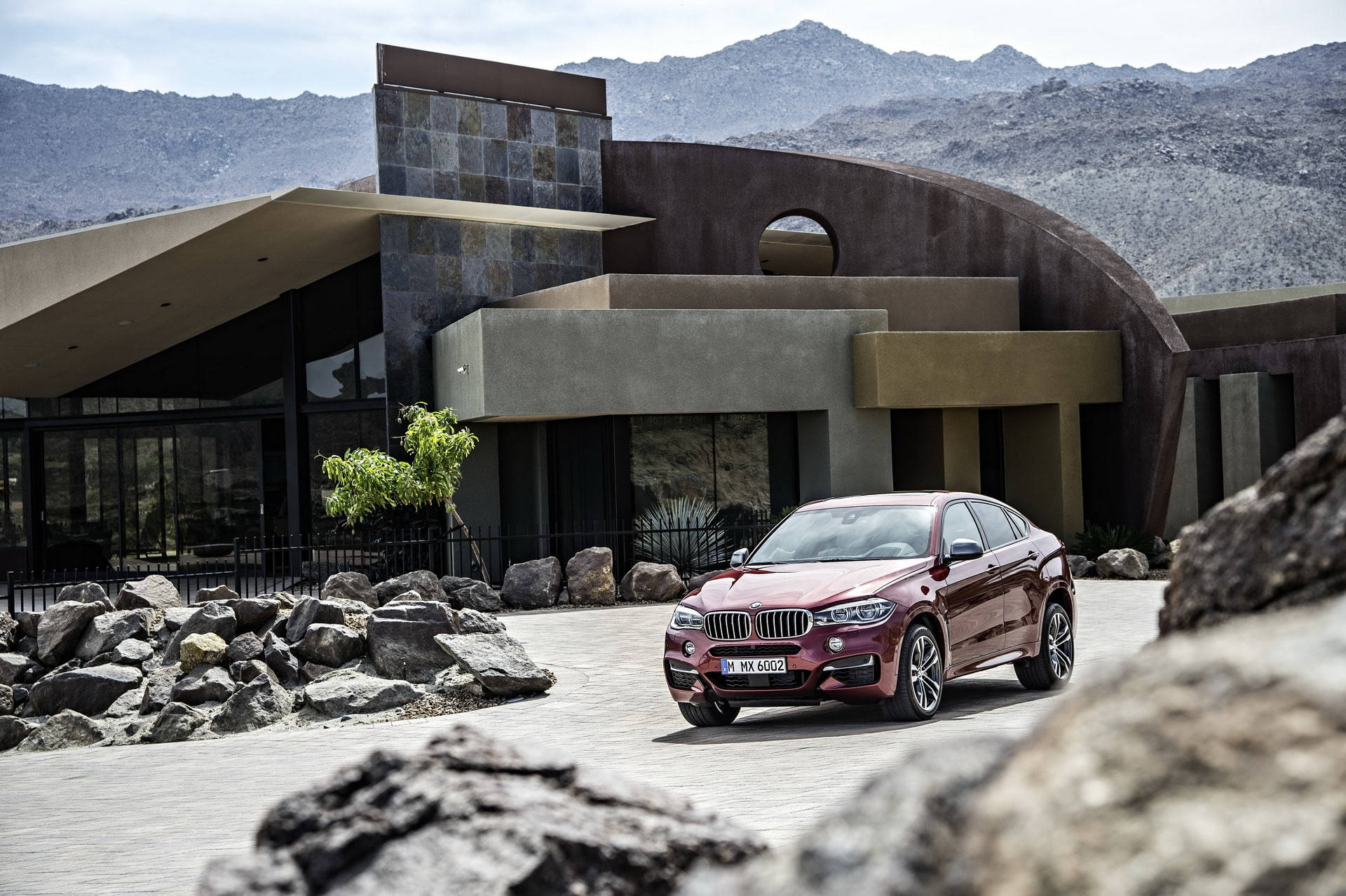 m 桌布 壁紙 — 一輛栗色BMW X6停放在現代沙漠屋前，背景有山脈。