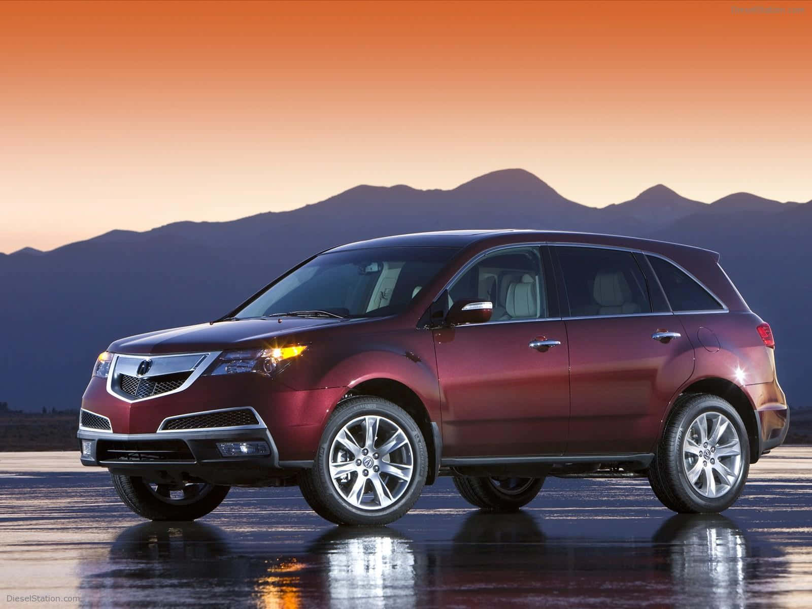 Acura Mdx 桌布 壁紙 — 一輛栗色SUV在日落時分的濕滑路面上閃閃發光，背後是橙色天空下的山脈剪影。