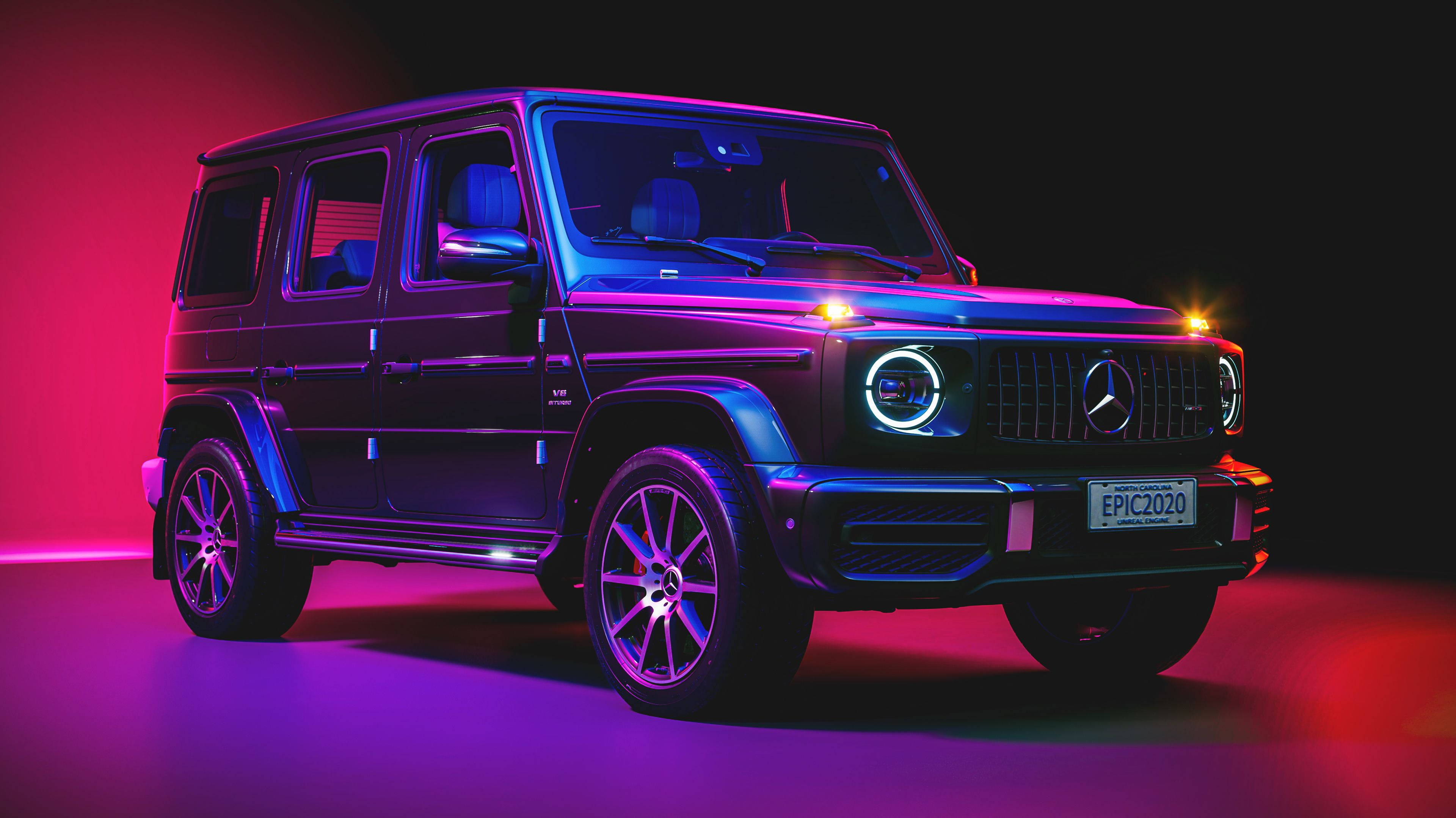 4K 奔馳壁紙 桌布 壁紙 — 一輛梅賽德斯 G-Class SUV 在黑暗的攝影棚背景下，在充滿活力的粉紅色和藍色霓虹燈下發光。