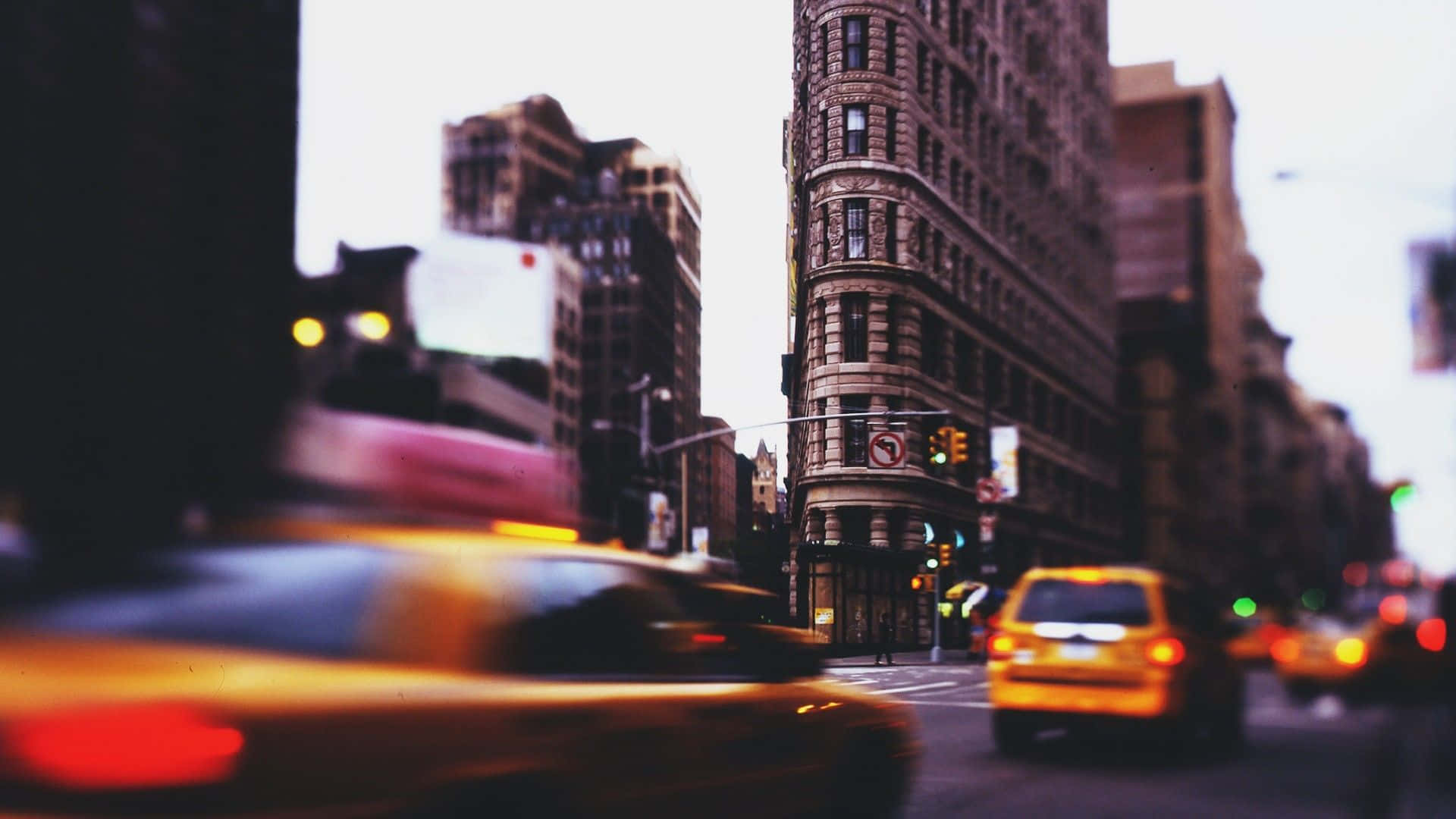 Motion Blur 桌布 壁紙 — 一輛模糊的黃色計程車在黃昏時分飛馳而過紐約市標誌性的熨斗大廈。