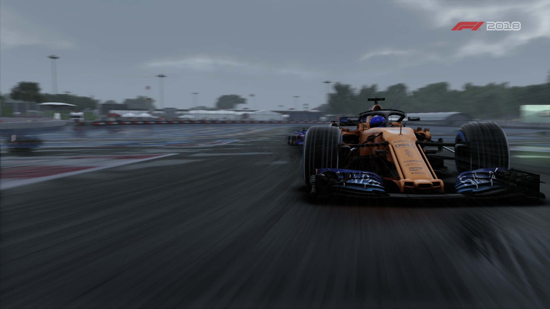 F1 2018 桌布 壁紙 — 一輛橙色一級方程式賽車在多雲天空下，於濕滑的賽道上疾馳，動態模糊效果強調了速度。