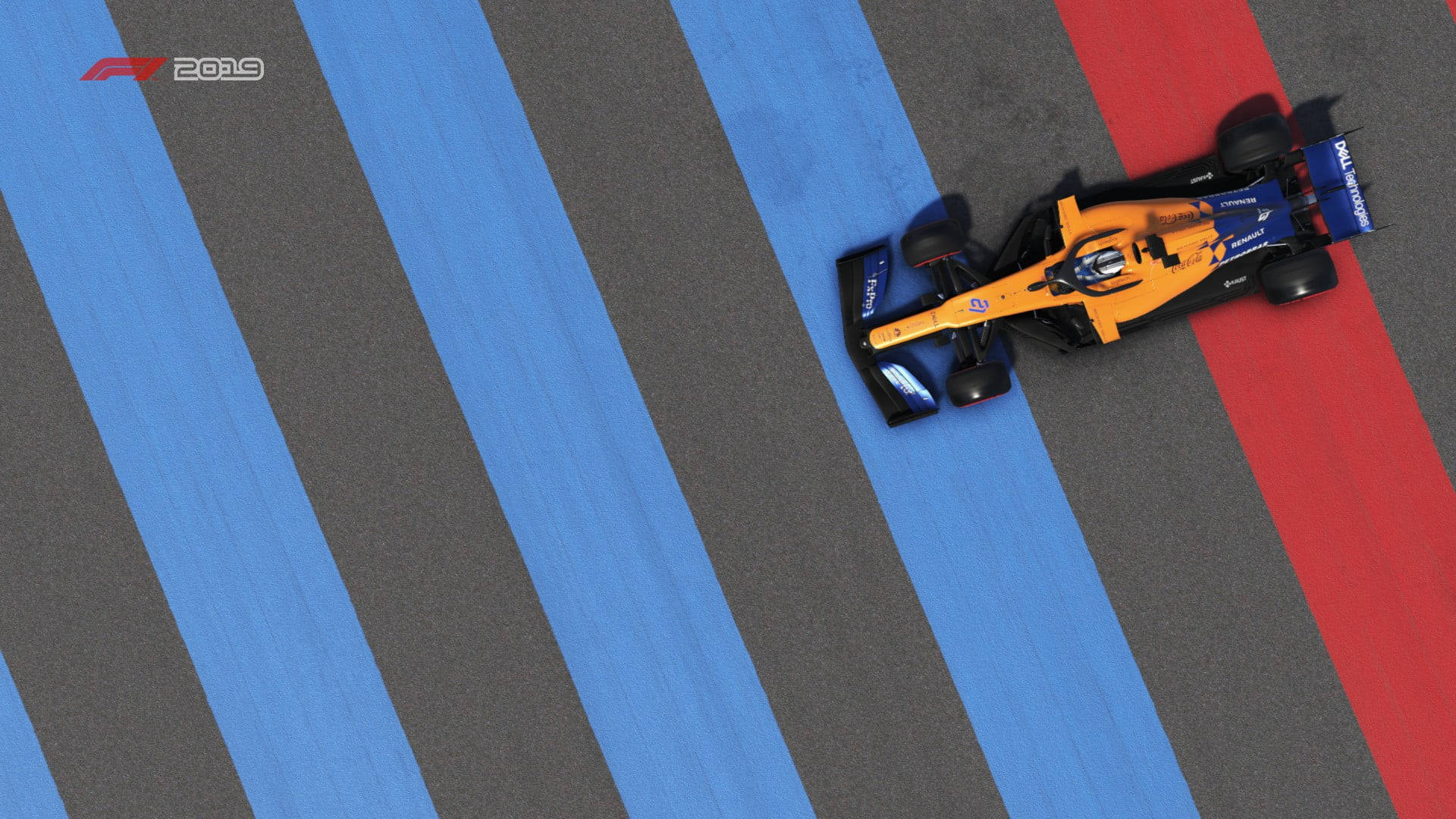 F1 桌布 壁紙 — 一輛橙色和藍色的 Formula 1 賽車在明亮的日光下，沿著帶有醒目藍色和紅色條紋的賽道奔馳。