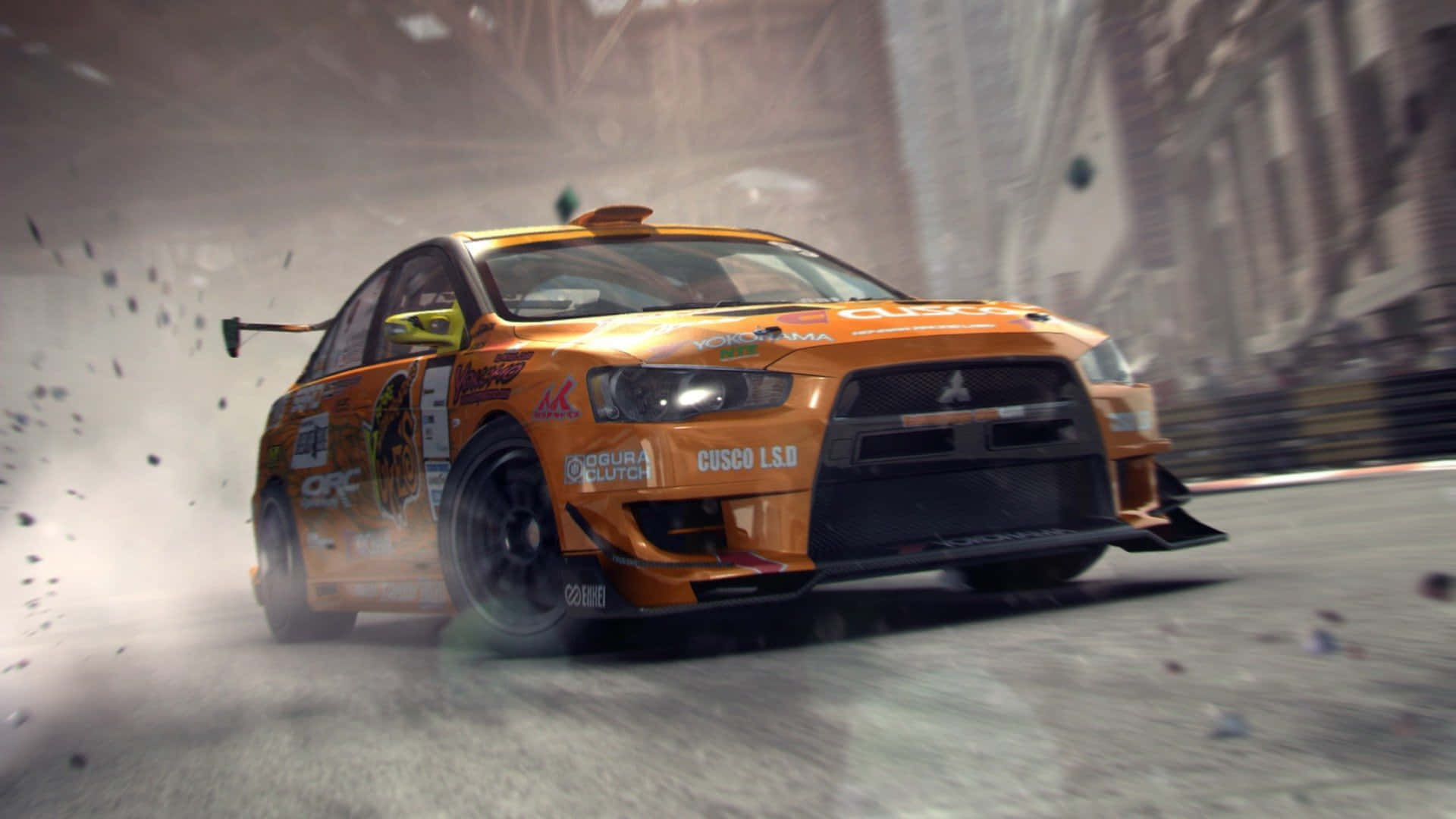 Grid 2 桌布 壁紙 — 一輛橙色拉力賽車在塵土飛揚的城市街道上激烈飄移，碎片飛揚，背景建築模糊。