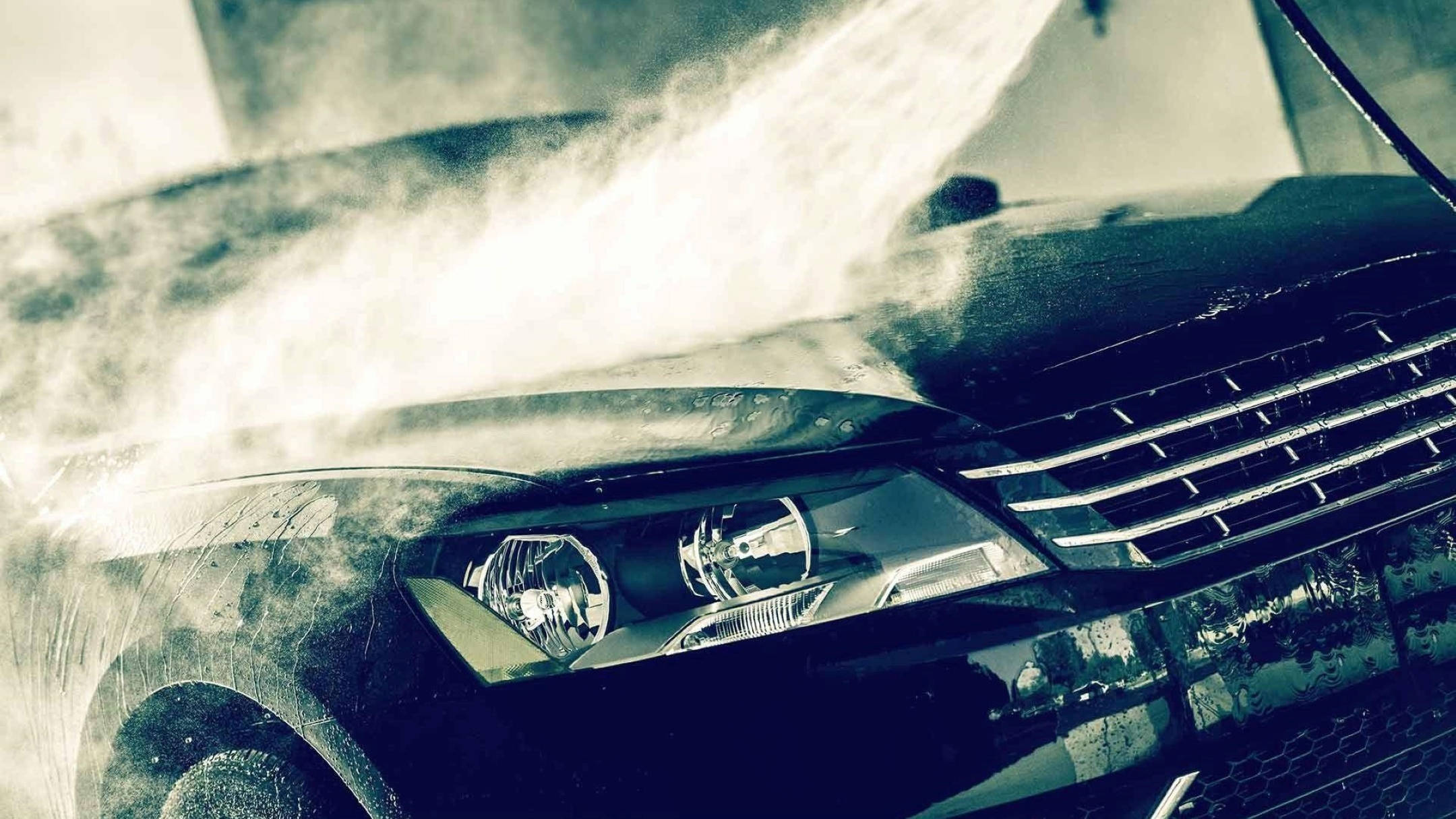 Wash 桌布 壁紙 — 一輛汽車正被強力水柱沖洗，水花濺到引擎蓋和格柵上。