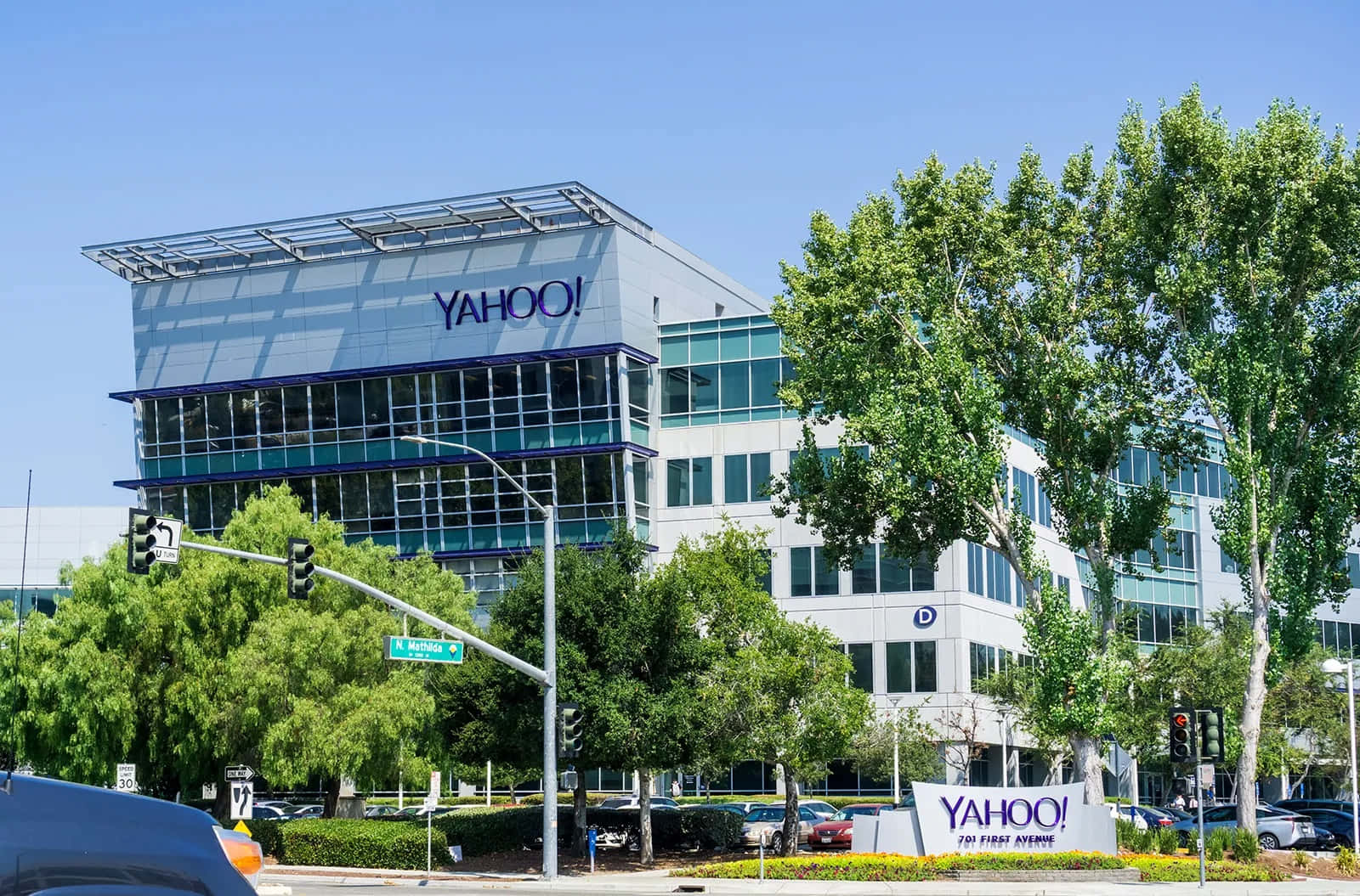一輛汽車駛過帶有Yahoo標誌的大型建築 壁紙