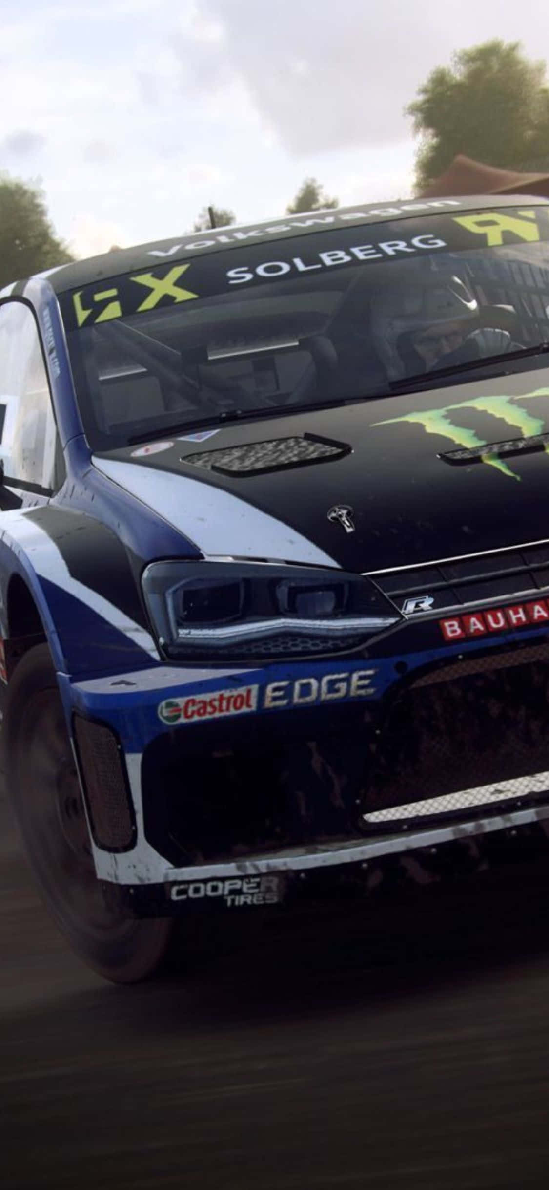 iPhone X Dirt Rally 桌布 壁紙 — 一輛沾滿泥濘的福斯汽車拉力賽車，帶有索爾伯格和Monster Energy貼花，在森林泥路上飛馳。