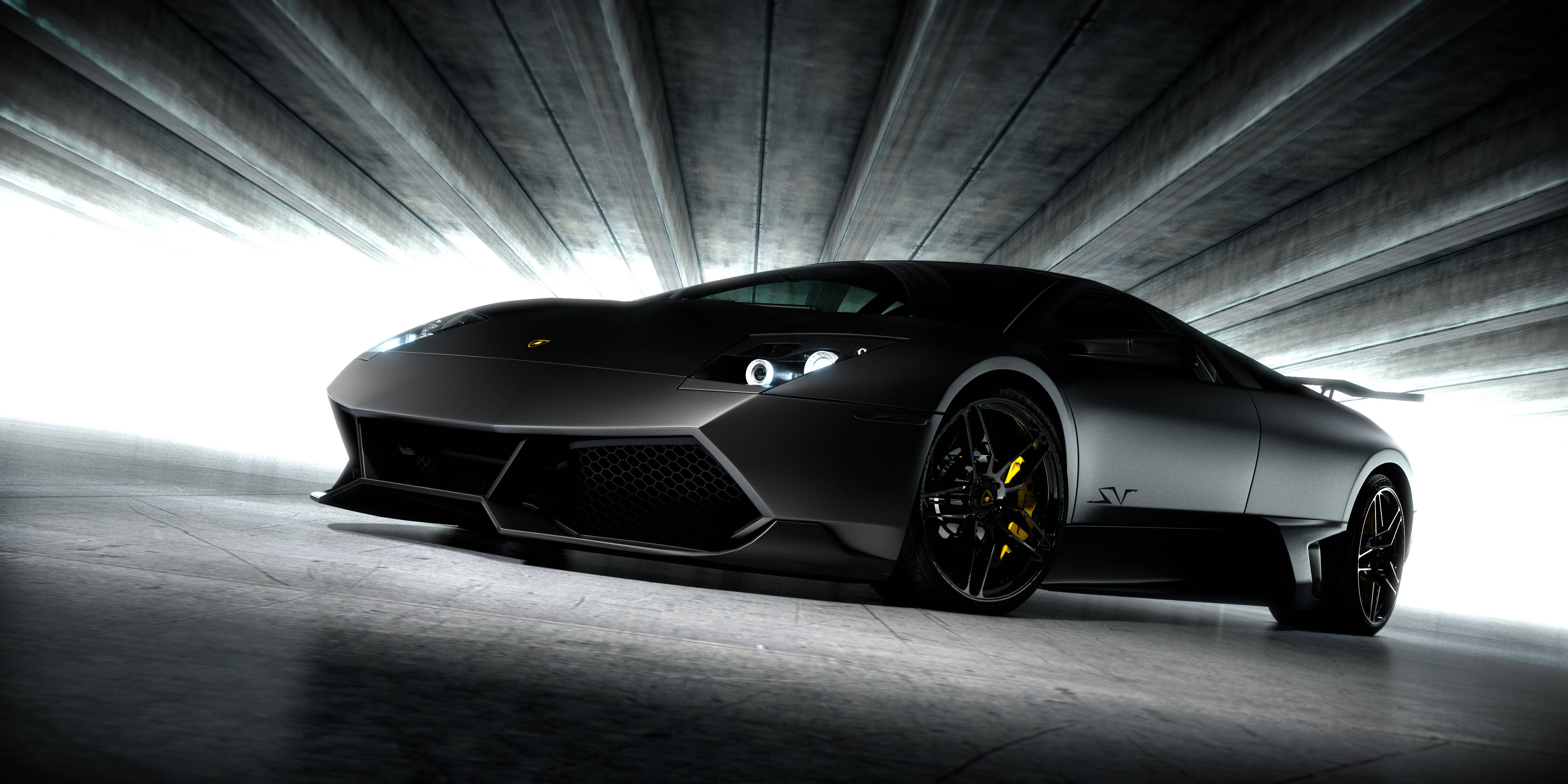4K Lamborghini 桌布 壁紙 — 一輛流線型啞黑色藍寶堅尼Reventon跑車在戲劇性的隧道燈光下閃閃發光，配備黃色制動卡鉗。