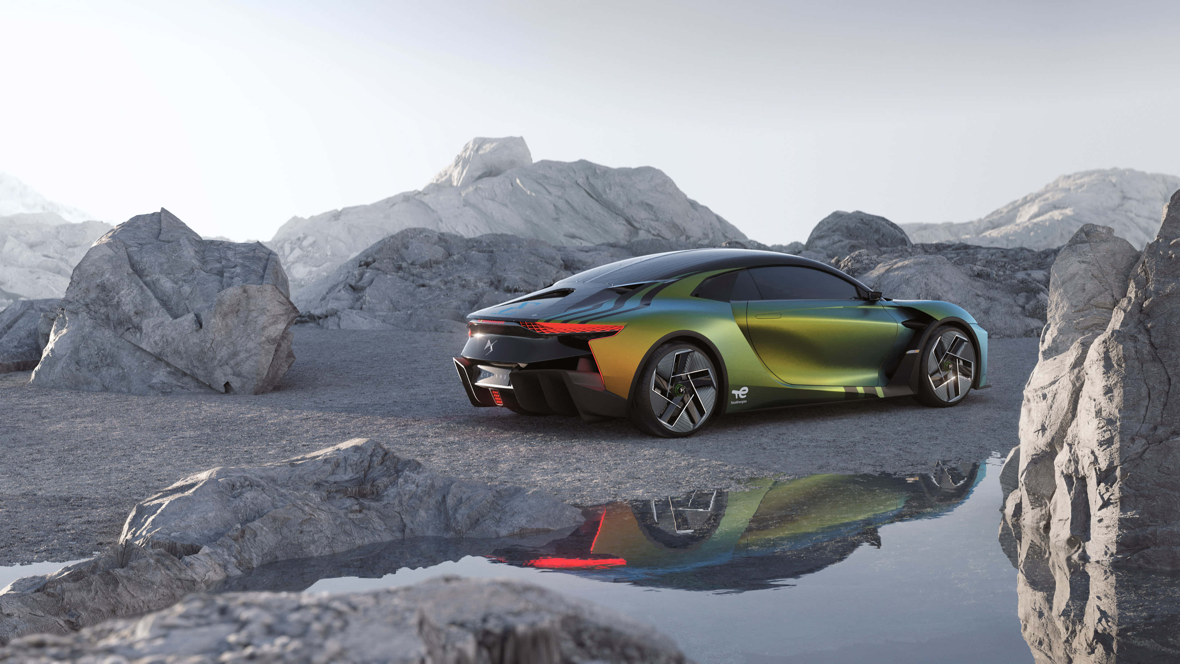 Ds Automobiles 桌布 壁紙 — 一輛流線型未來感跑車，帶有彩虹綠色車漆，停在岩石地形上，旁邊有一個反射水坑，在明亮的日光下。