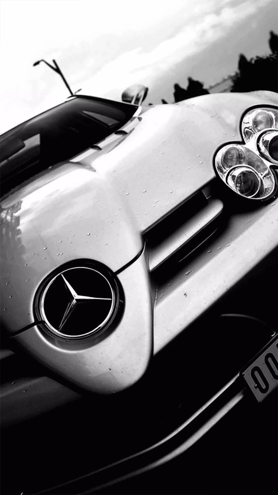 AMG iPhone 桌布 壁紙 — 一輛流線型梅賽德斯跑車彎曲引擎蓋上閃爍著雨滴的黑白特寫。