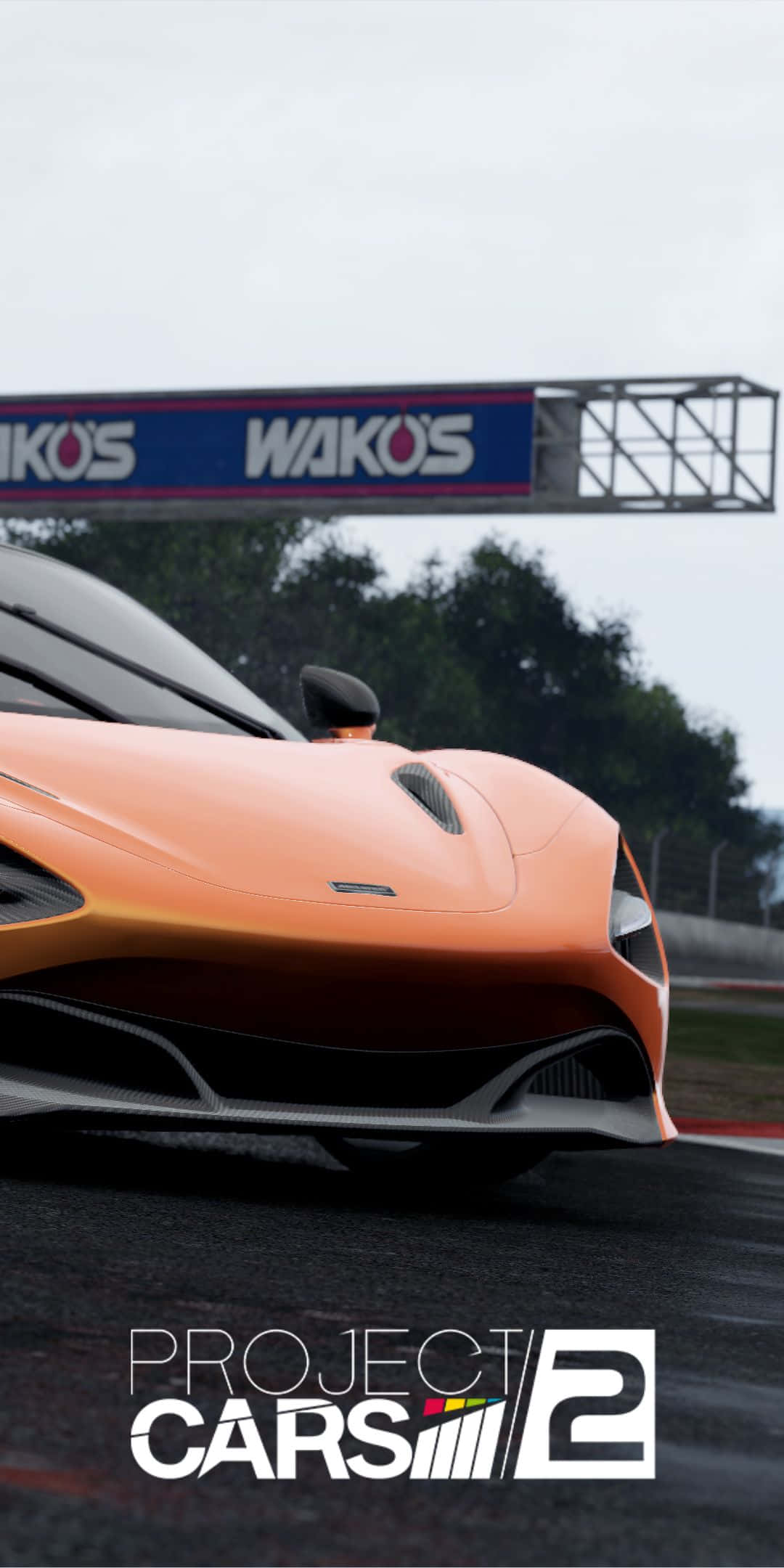 Pixel 3 Project Cars 2 桌布 壁紙 — 一輛流線型橙色賽車在潮濕的賽道上疾馳，天空多雲，頭頂有 'WAKOS' 標誌。