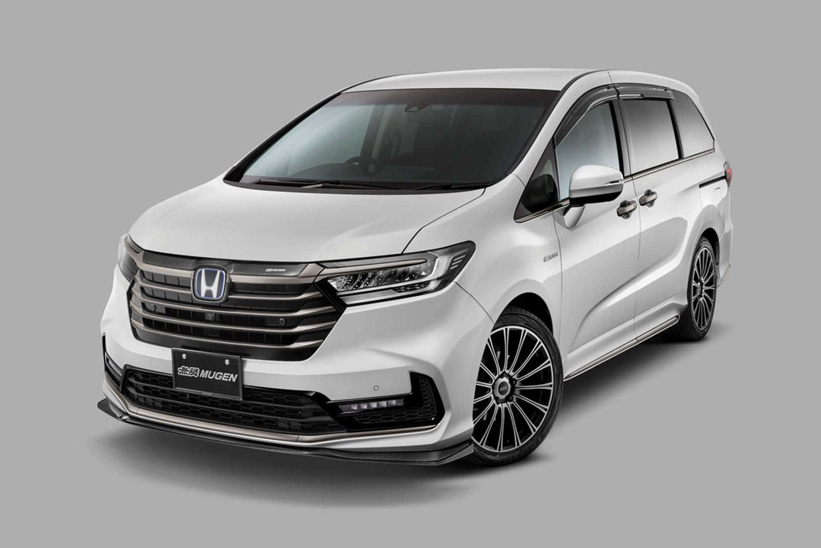 2023 Honda Pilot 桌布 壁紙 — 一輛流線型白色本田Odyssey廂型休旅車，配備Mugen改裝飾件及黑色多幅式輪圈，背景為中性灰色攝影棚。
