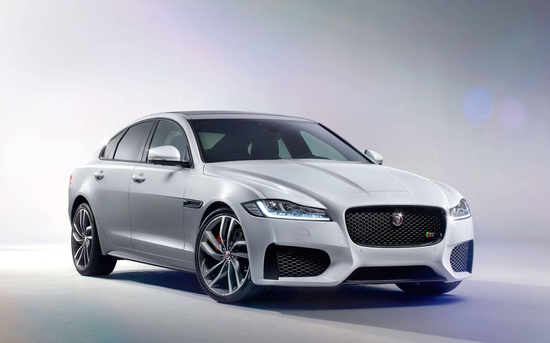 美洲豹汽車 桌布 壁紙 — 一輛流線型的銀色Jaguar XF Sportbrake在柔和的工作室燈光下閃閃發光，背景為模糊漸變。