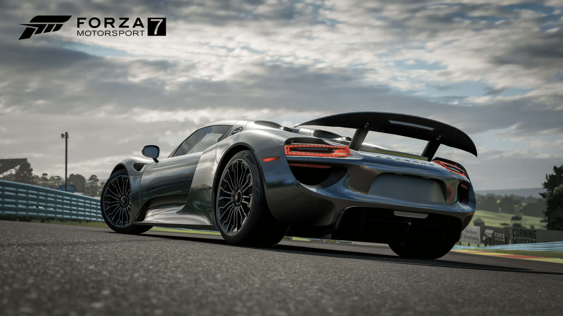 1080p Forza Motorsport 7 桌布 壁紙 — 一輛流線型的銀色保時捷918 Spyder在潮濕的瀝青賽道上奔馳，天空多雲，遠處有綠色山丘。