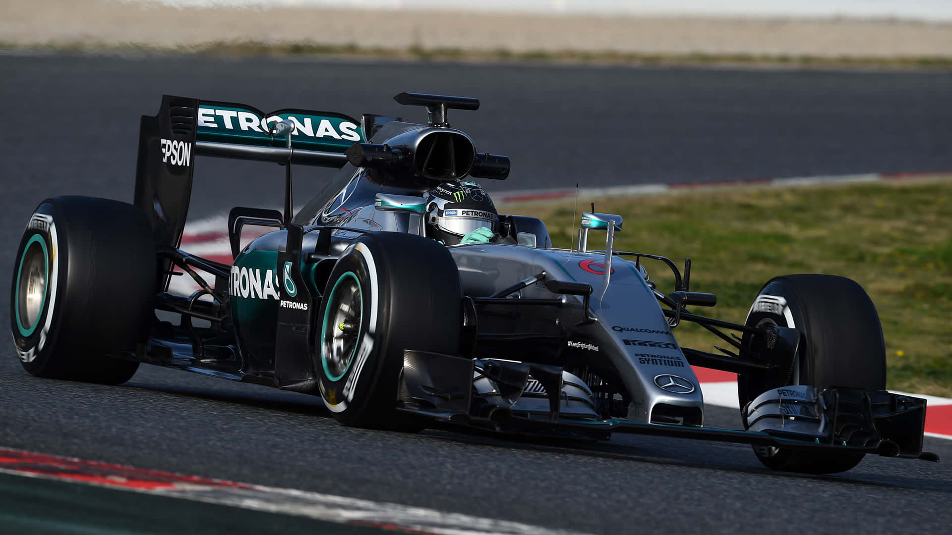 F1 2016 桌布 壁紙 — 一輛流線型的銀色和藍綠色一級方程式賽車在明亮的日光下，沿著設有紅色和白色路緣的賽道疾馳。