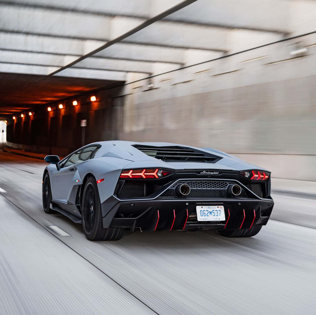 Black Car 桌布 壁紙 — 一輛流線型的銀色藍寶堅尼Aventador在混凝土隧道中飛馳，動態模糊效果強調其速度。